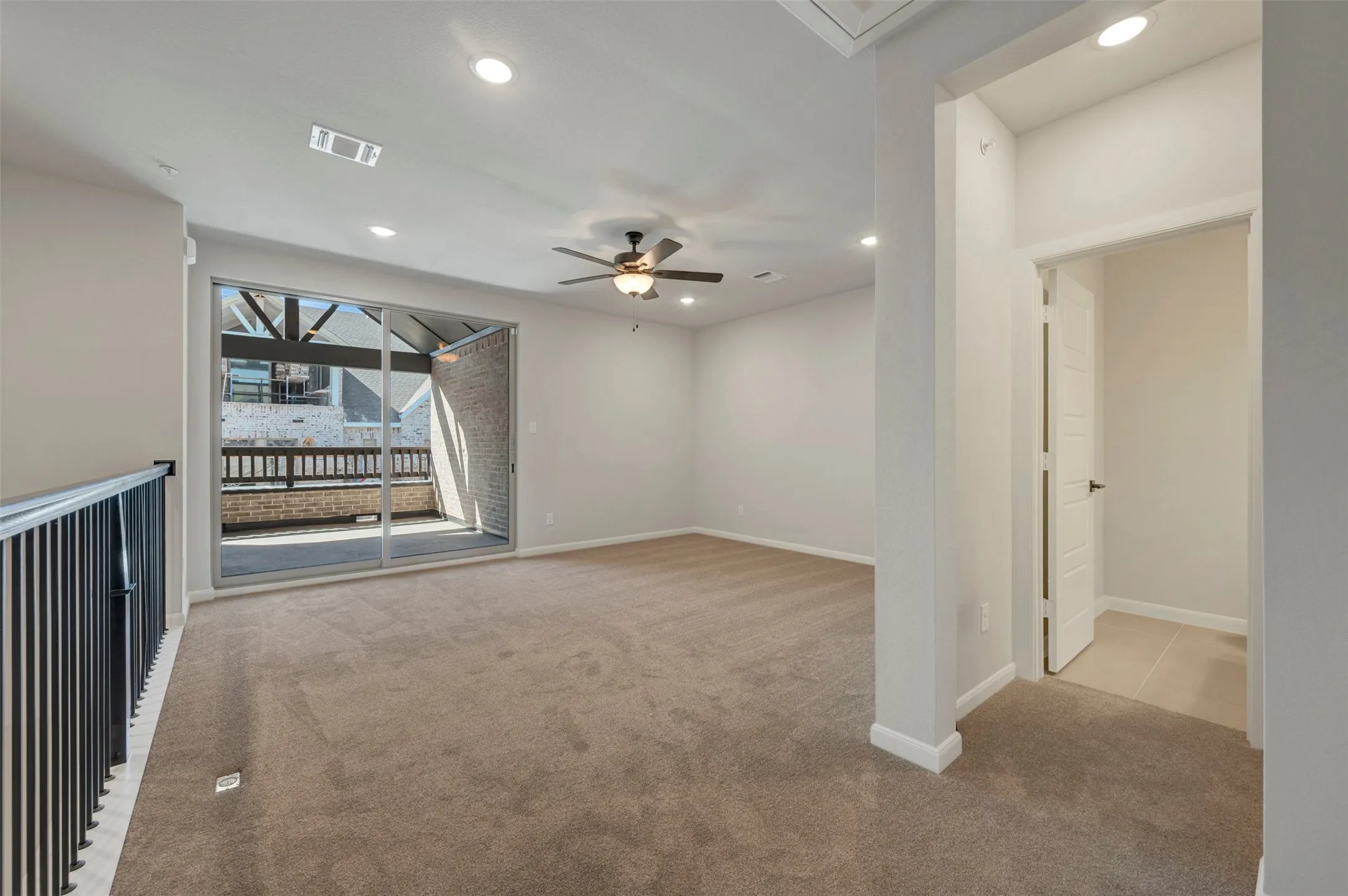 Spacious room featuring neutral carpeting, recessed lighting, and a ceiling fan