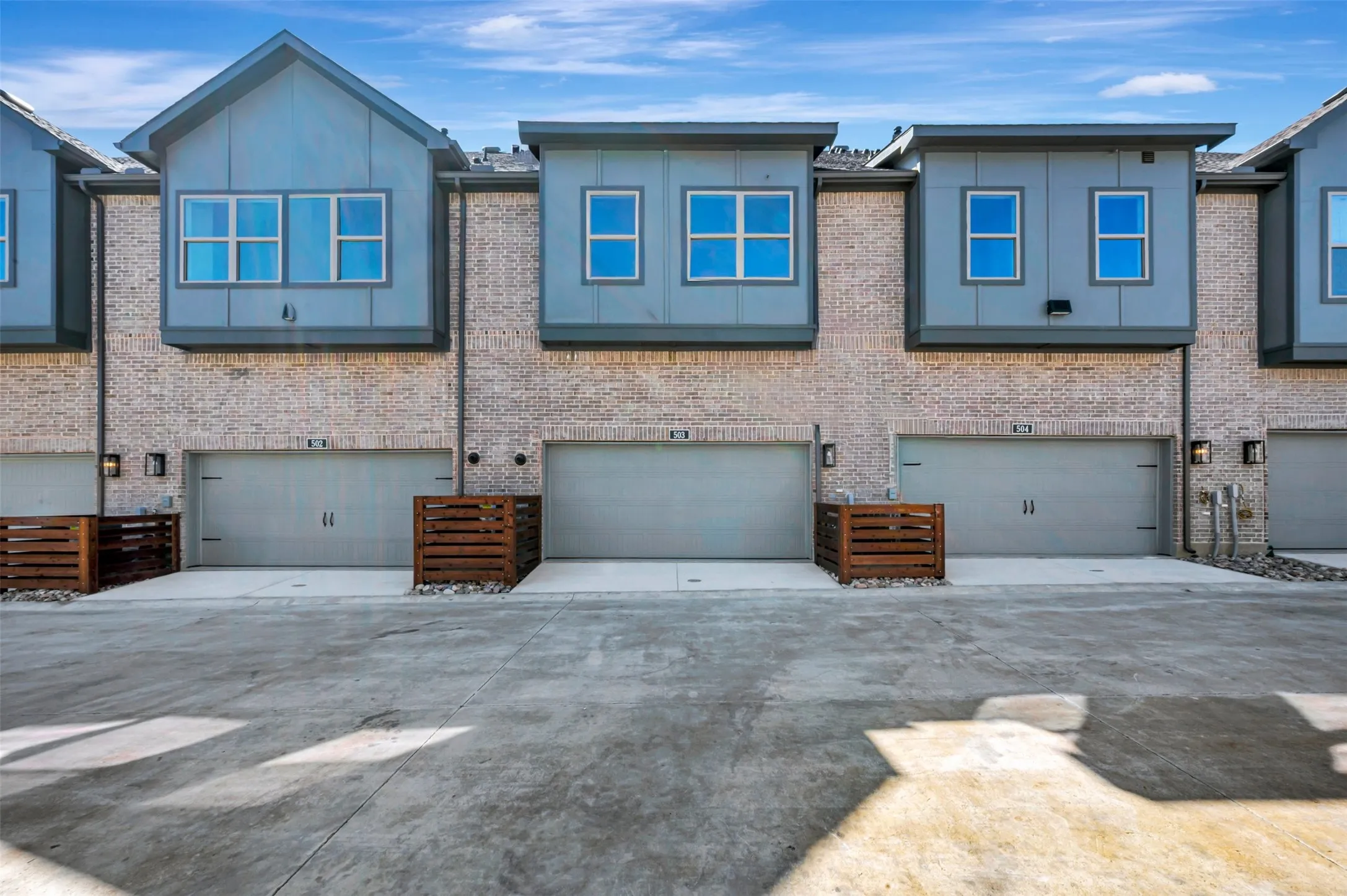Brick exterior with dark gray siding accents and multiple windows