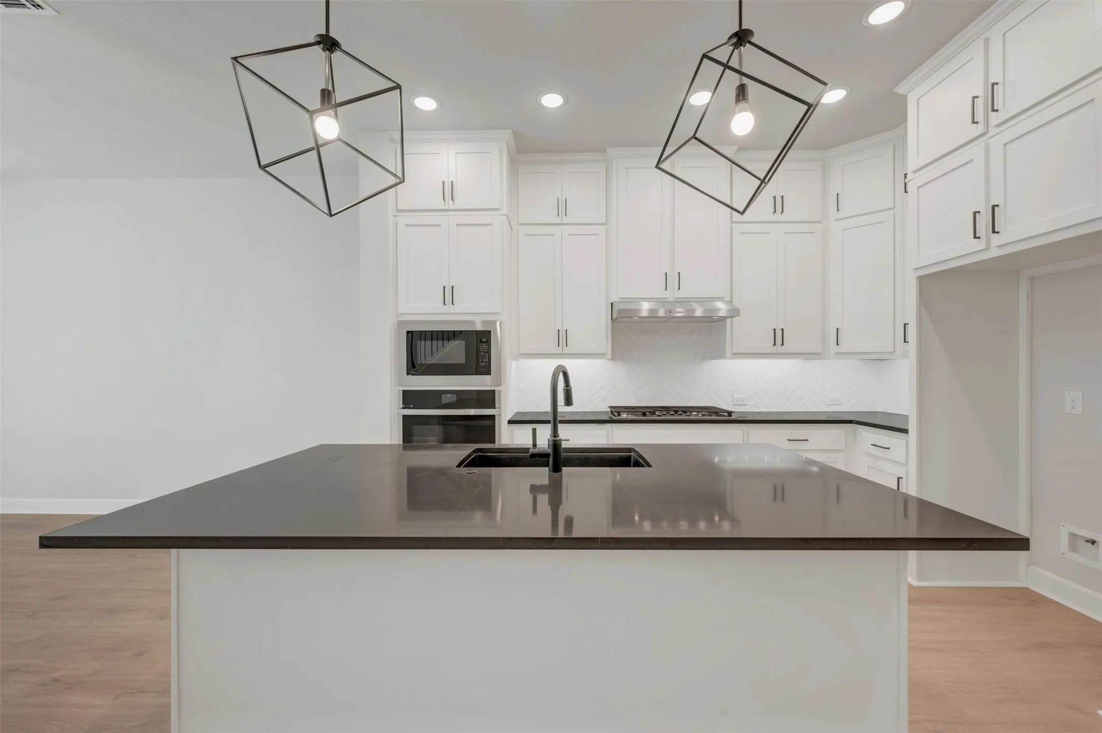 Central island with a dark countertop and undermount sink