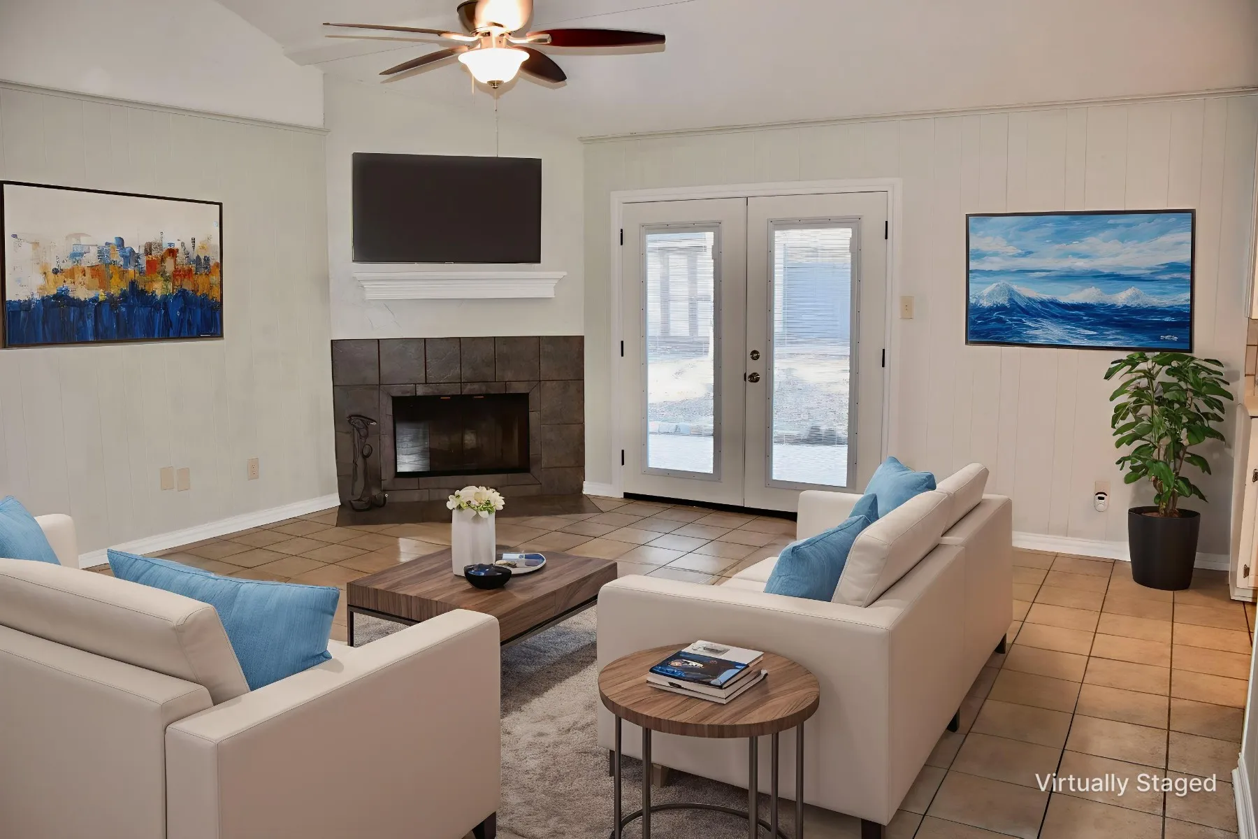 Living area featuring a corner tile fireplace with a white mantel, vaulted ceiling with a ceiling fan, and tile flooring