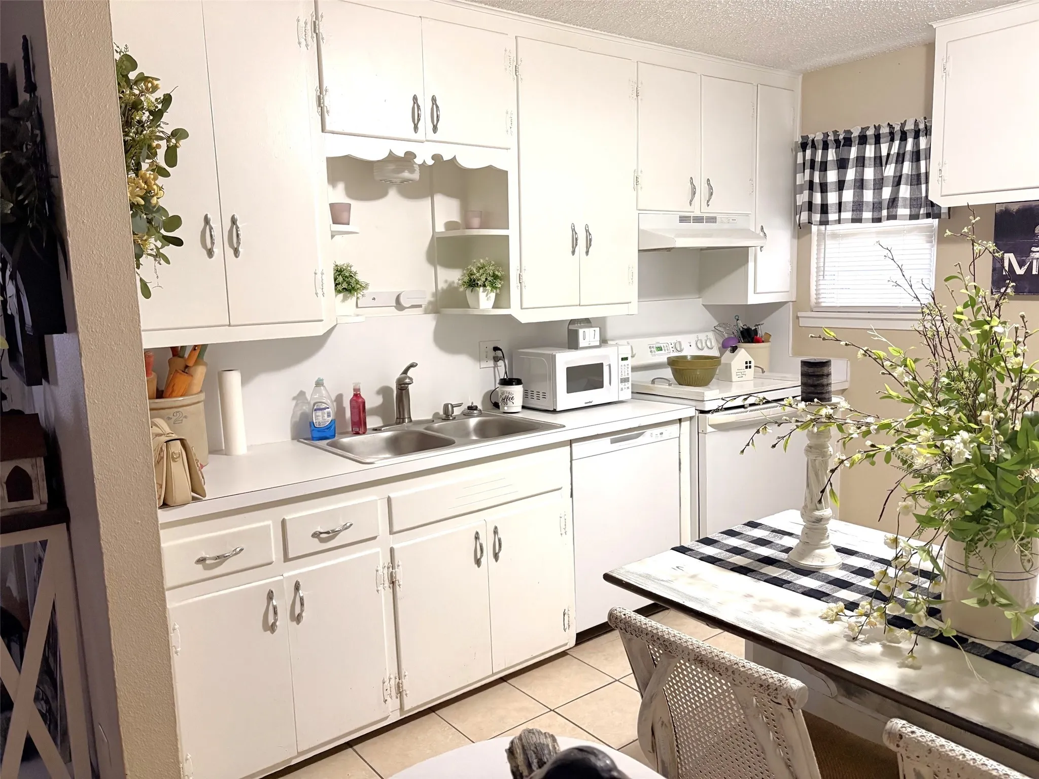 Kitchen featuring white cabinetry and light-toned countertops