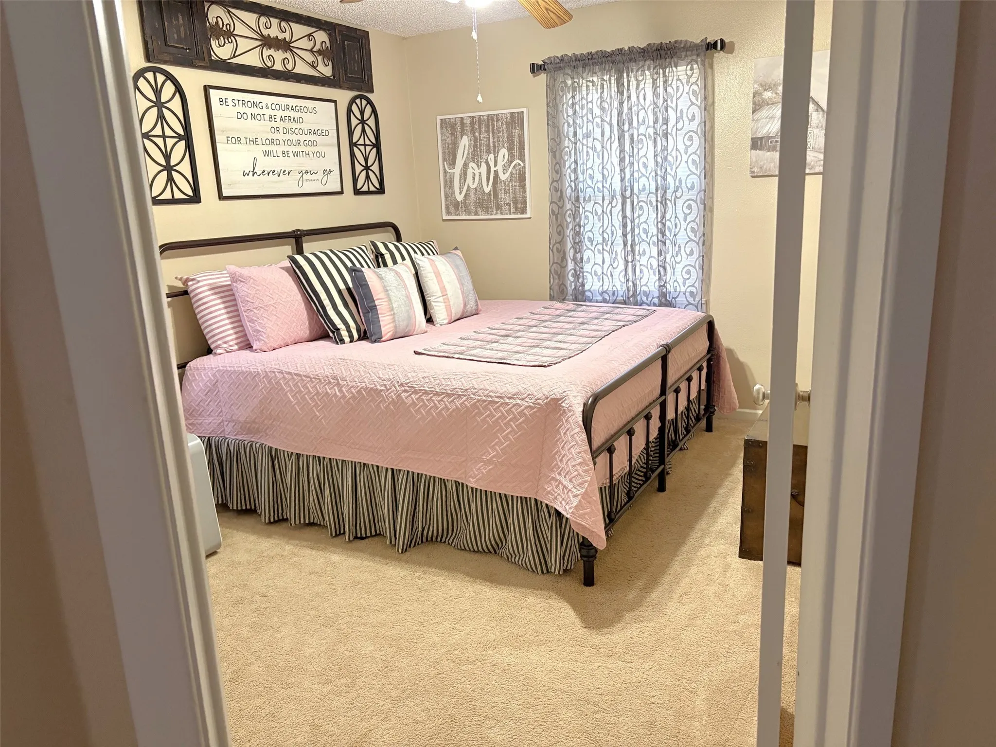 Carpeted room featuring a ceiling fan, window with curtain rods, and neutral wall tones