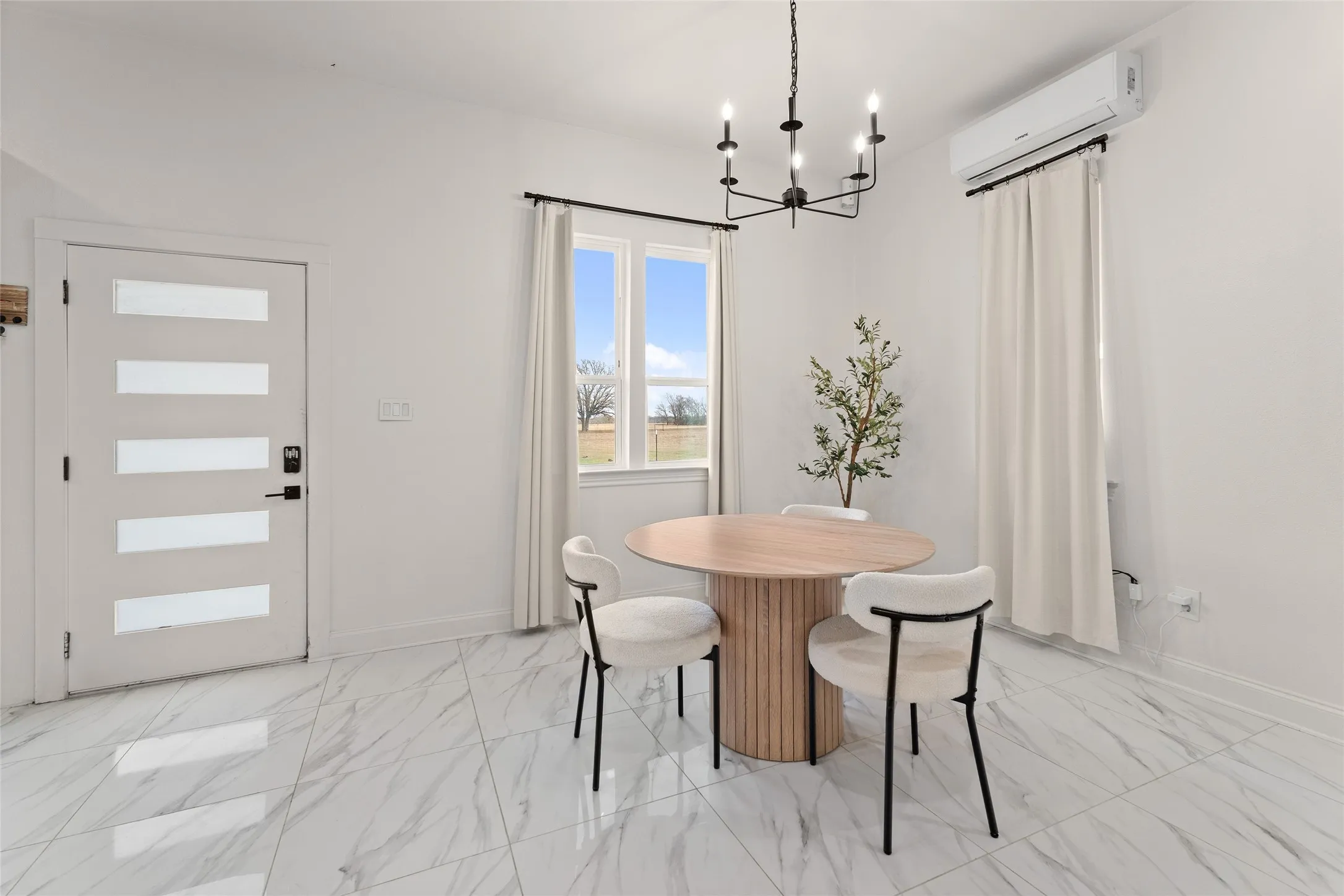 Bright interior space featuring white walls and marble-look tile flooring