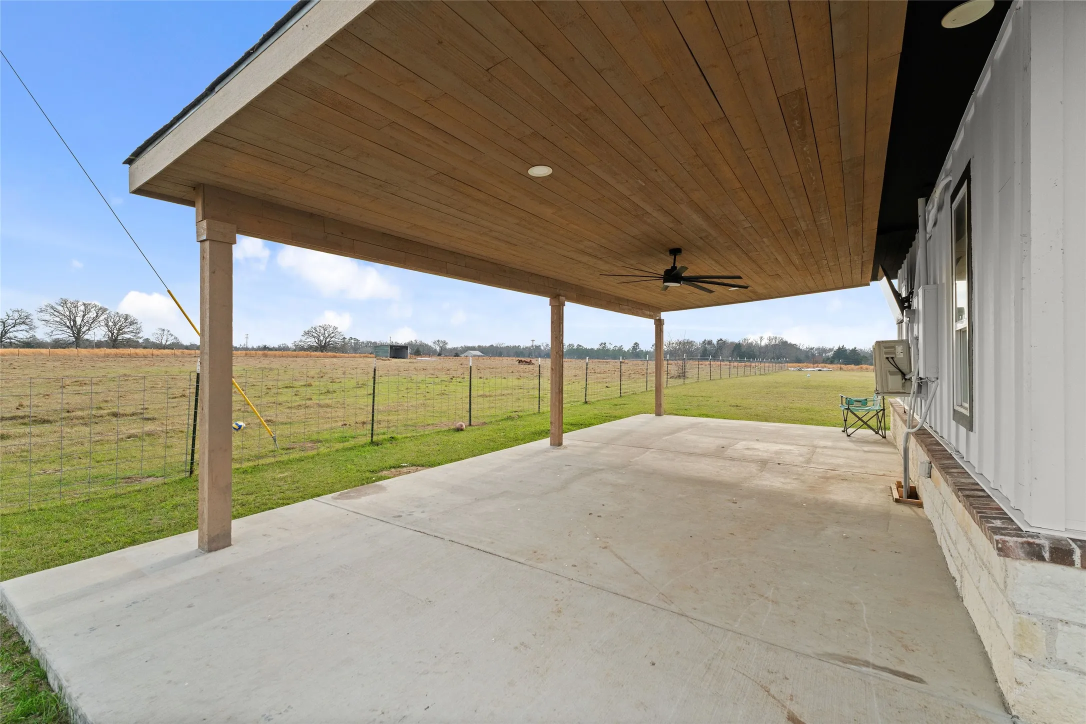 Spacious concrete patio featuring a wood-finish ceiling, recessed lighting, and a ceiling fan
