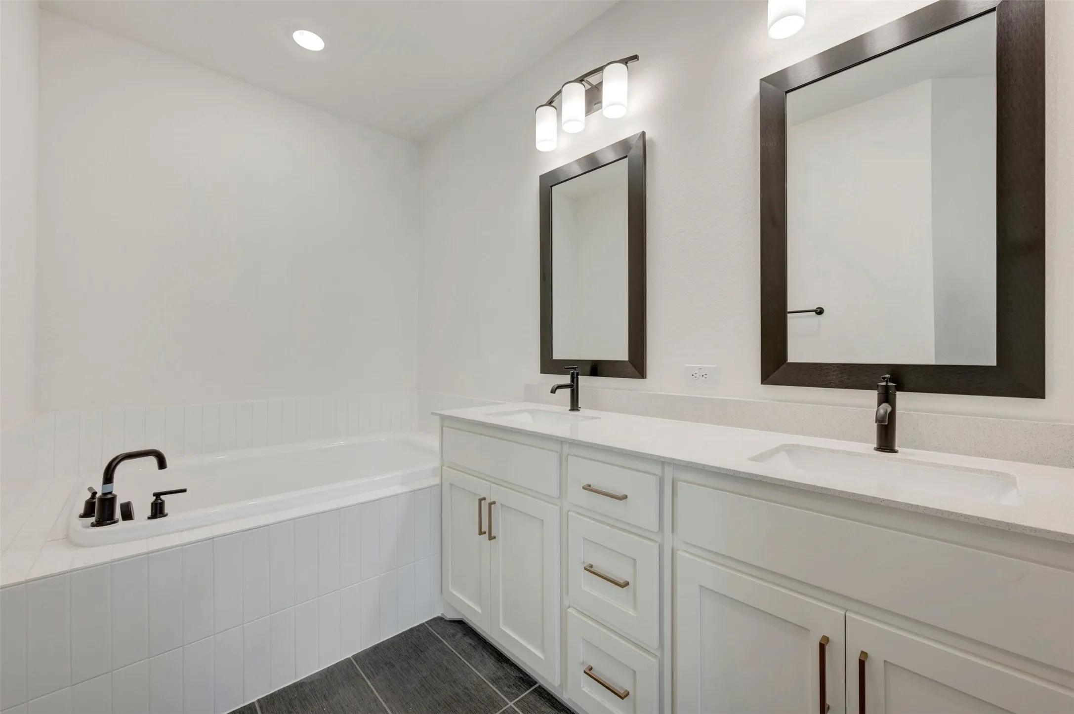 Dual vanities with white cabinetry and integrated sinks