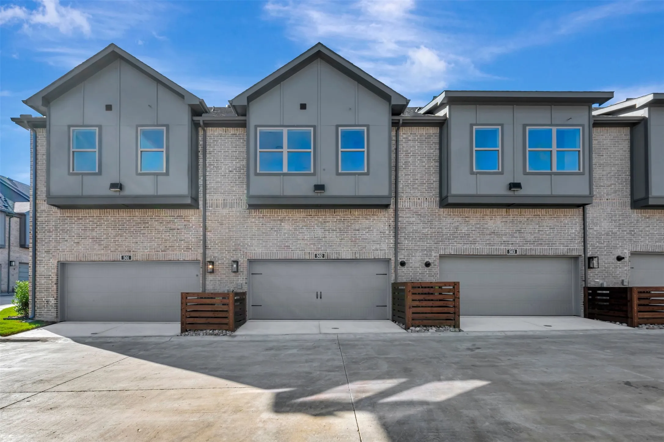 Modern townhome exterior with light brick and gray paneling