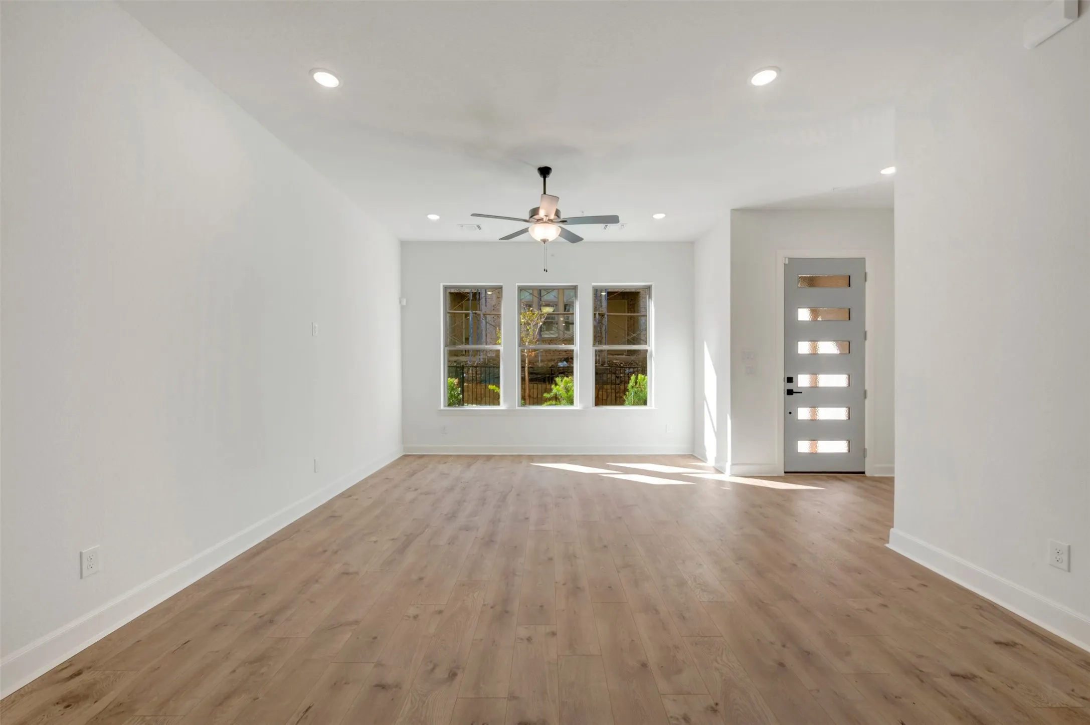 Wood-finish flooring, recessed lighting, and a ceiling fan with light