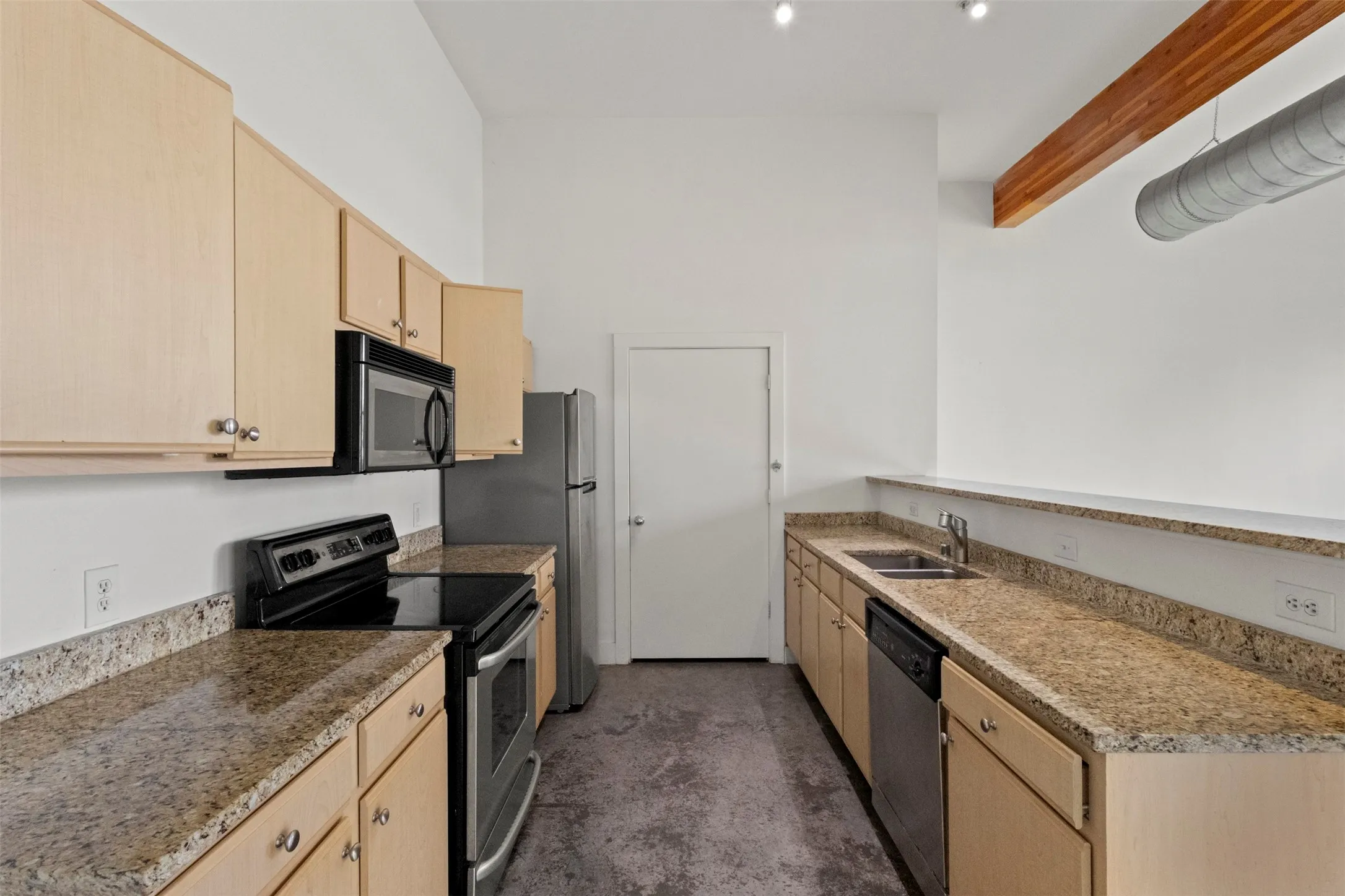 Kitchen featuring light-toned cabinetry, granite-finish countertops, stainless steel appliances, and a polished concrete floor
