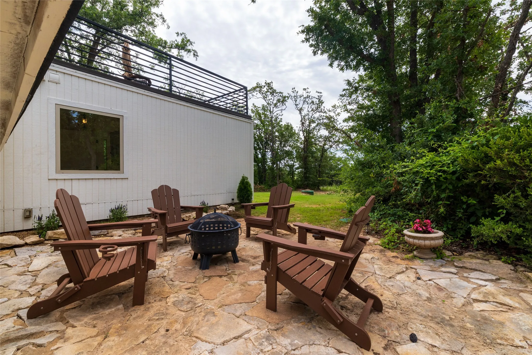 The courtyard creates the ideal space for gathering around a firepit. Just behind it, you will find the main floor Primary Suite with a rooftop deck.
