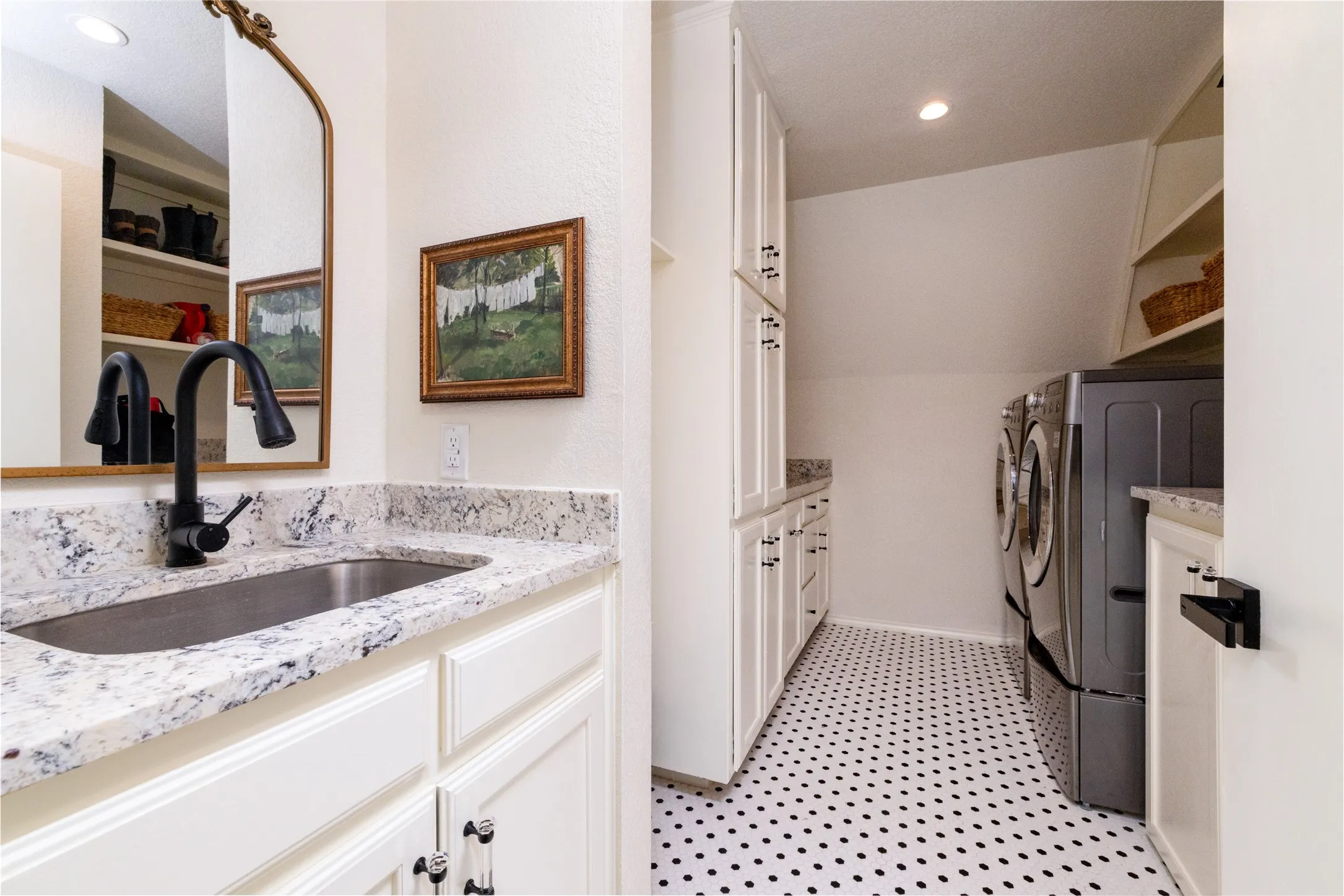 Expansive Laundry Room delivers ample storage and the convenience of an aesthetically pleasing vanity situated utility sink.