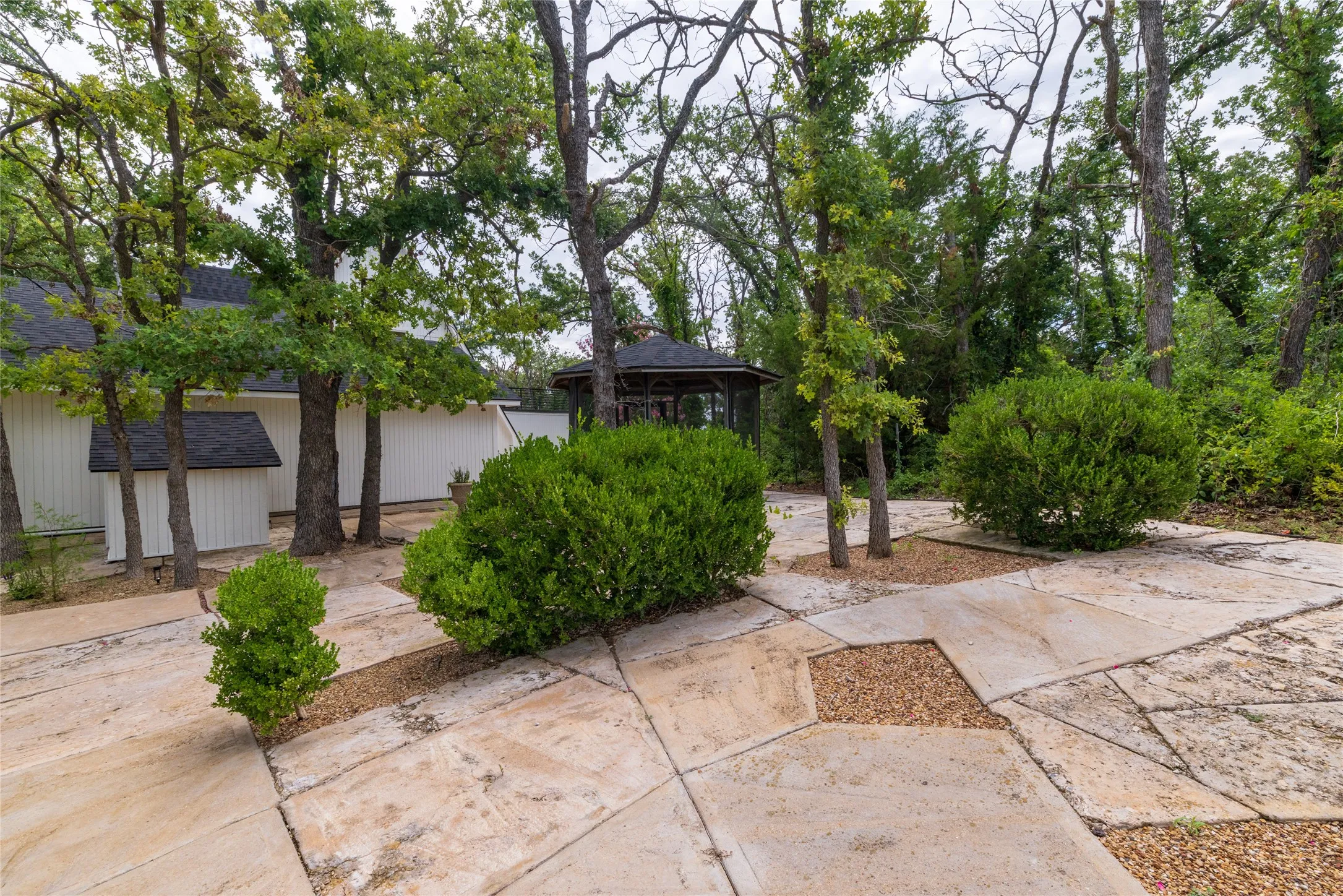 Additional View of the landscaped property with extensive rock work and countless trees.