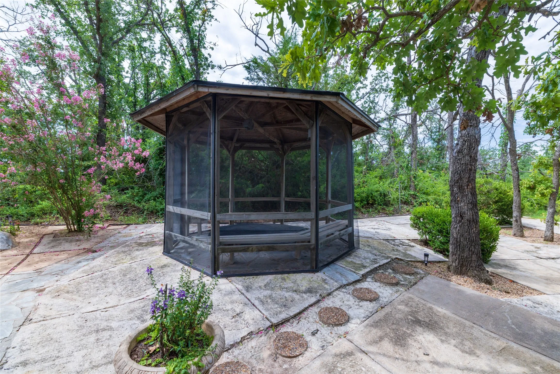 The screened in gazebo features an in-ground hot tub.