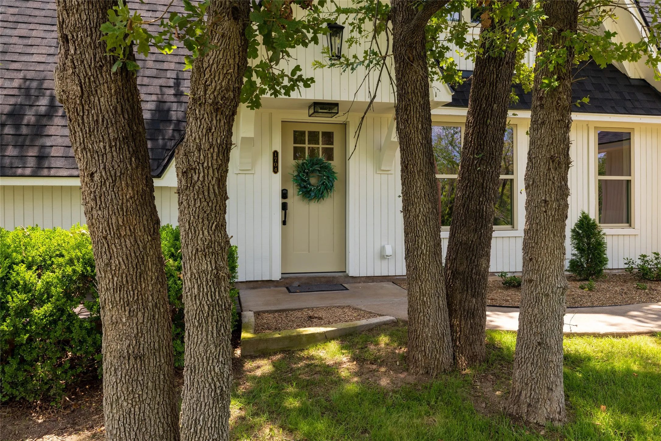 A peek through the mature trees of the front door entry.