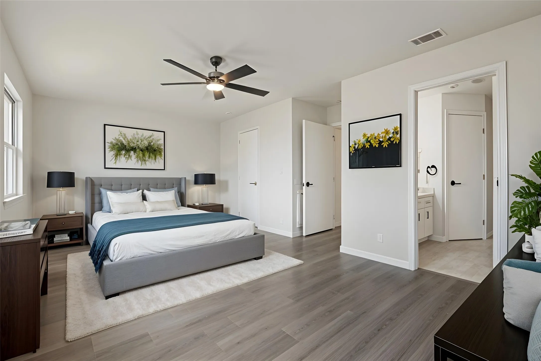 Spacious room featuring wood-finish flooring, a ceiling fan with integrated lighting, and multiple windows