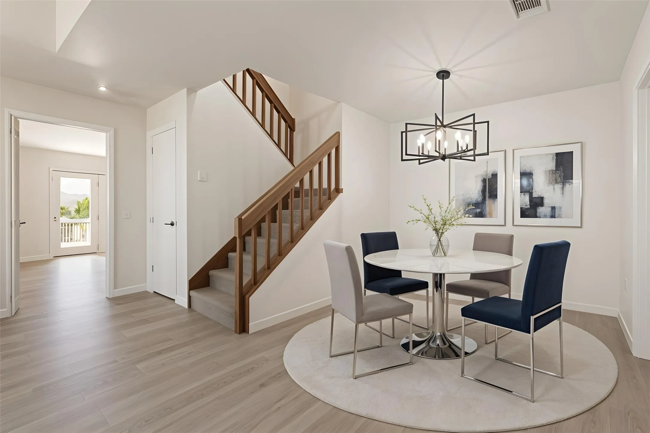Hardwood-finish flooring, a contemporary chandelier, a carpeted staircase with wood banister, and a double-door entry