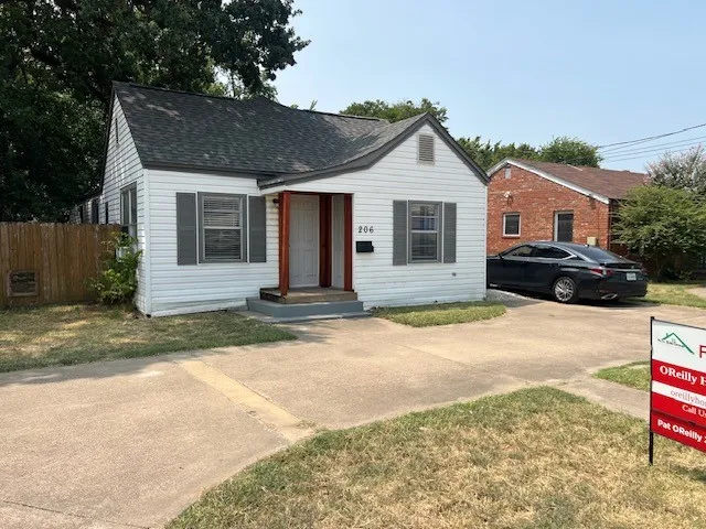 White siding exterior with a dark shingle roof and a covered porch