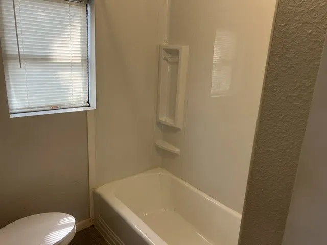 White tub and shower surround with integrated shelving