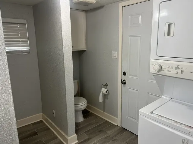 Dedicated laundry area featuring a stacked washer and dryer unit