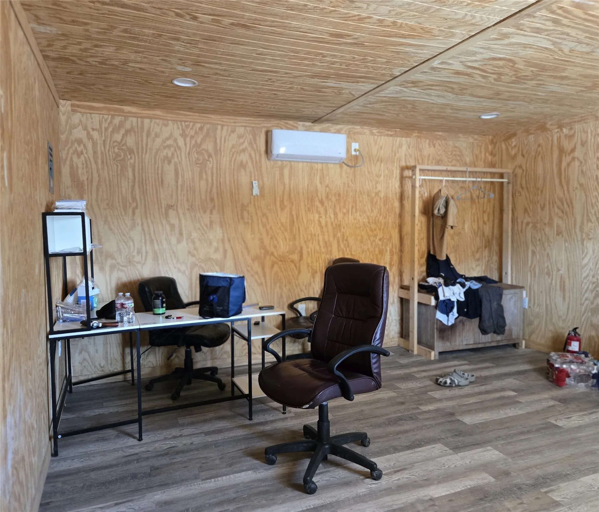 Wood-paneled room featuring recessed ceiling lighting and a wall-mounted mini-split system