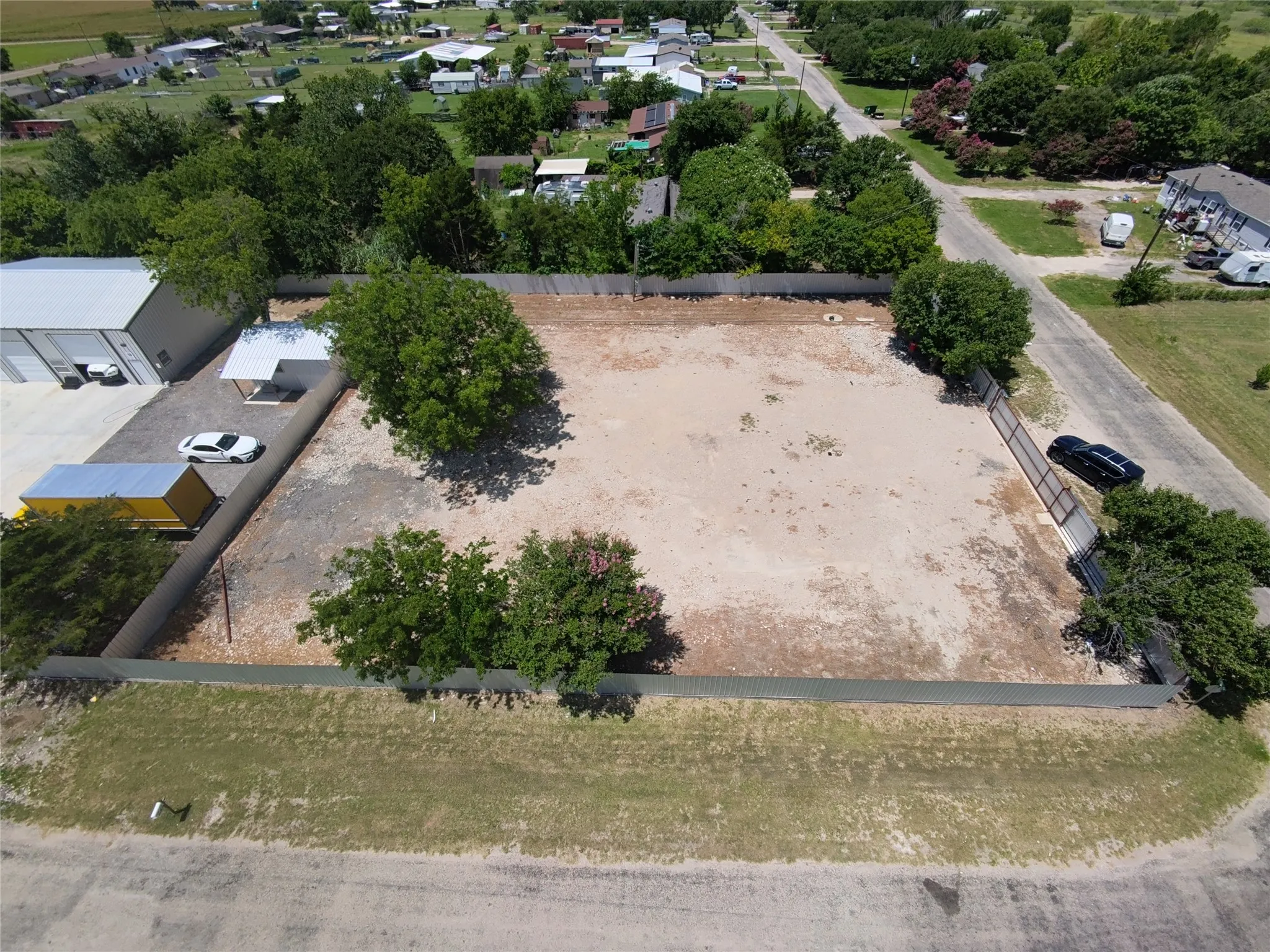 Spacious, clear lot featuring perimeter fencing, mature trees, and direct road frontage