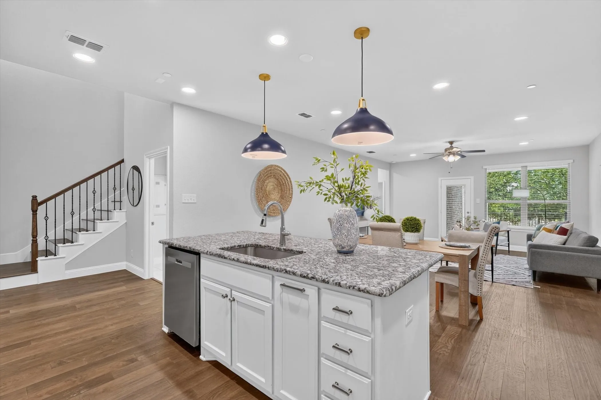 Kitchen island with granite countertop, integrated sink, and stainless steel dishwasher