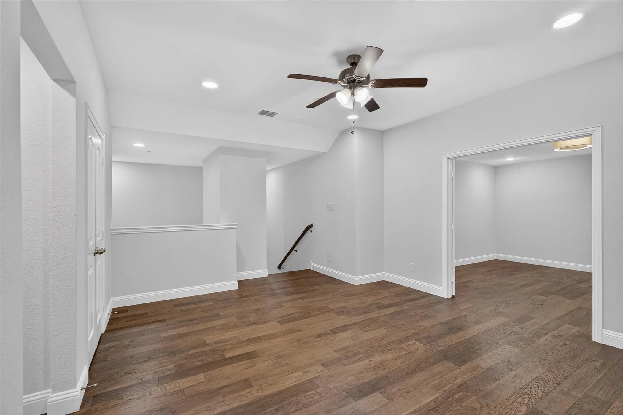 Expansive room featuring wood-finish flooring, recessed lighting, and a ceiling fan