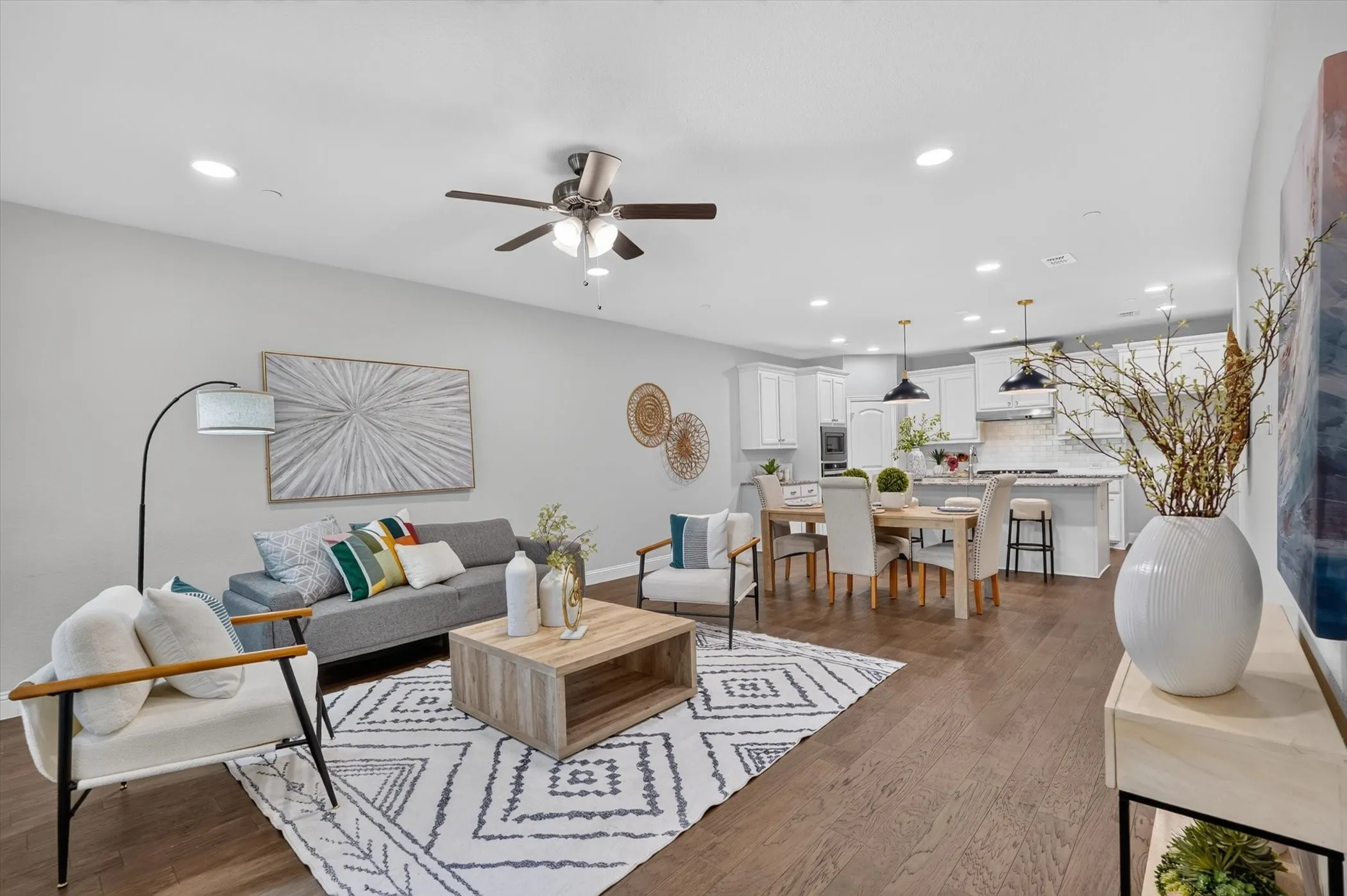 Open-concept living space featuring wood-finish flooring, recessed lighting, and a ceiling fan
