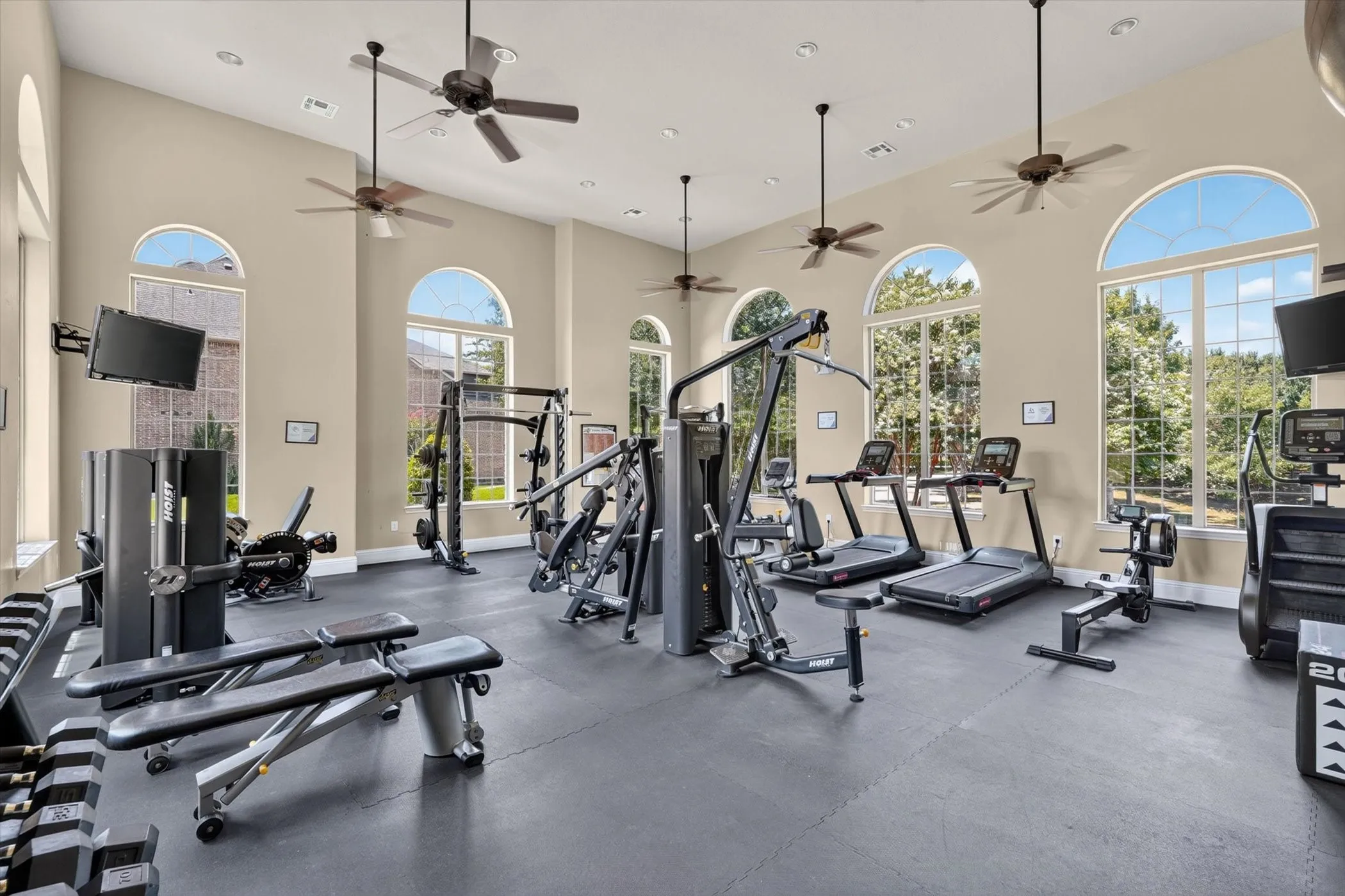 Dedicated fitness space featuring high ceilings and multiple arched windows