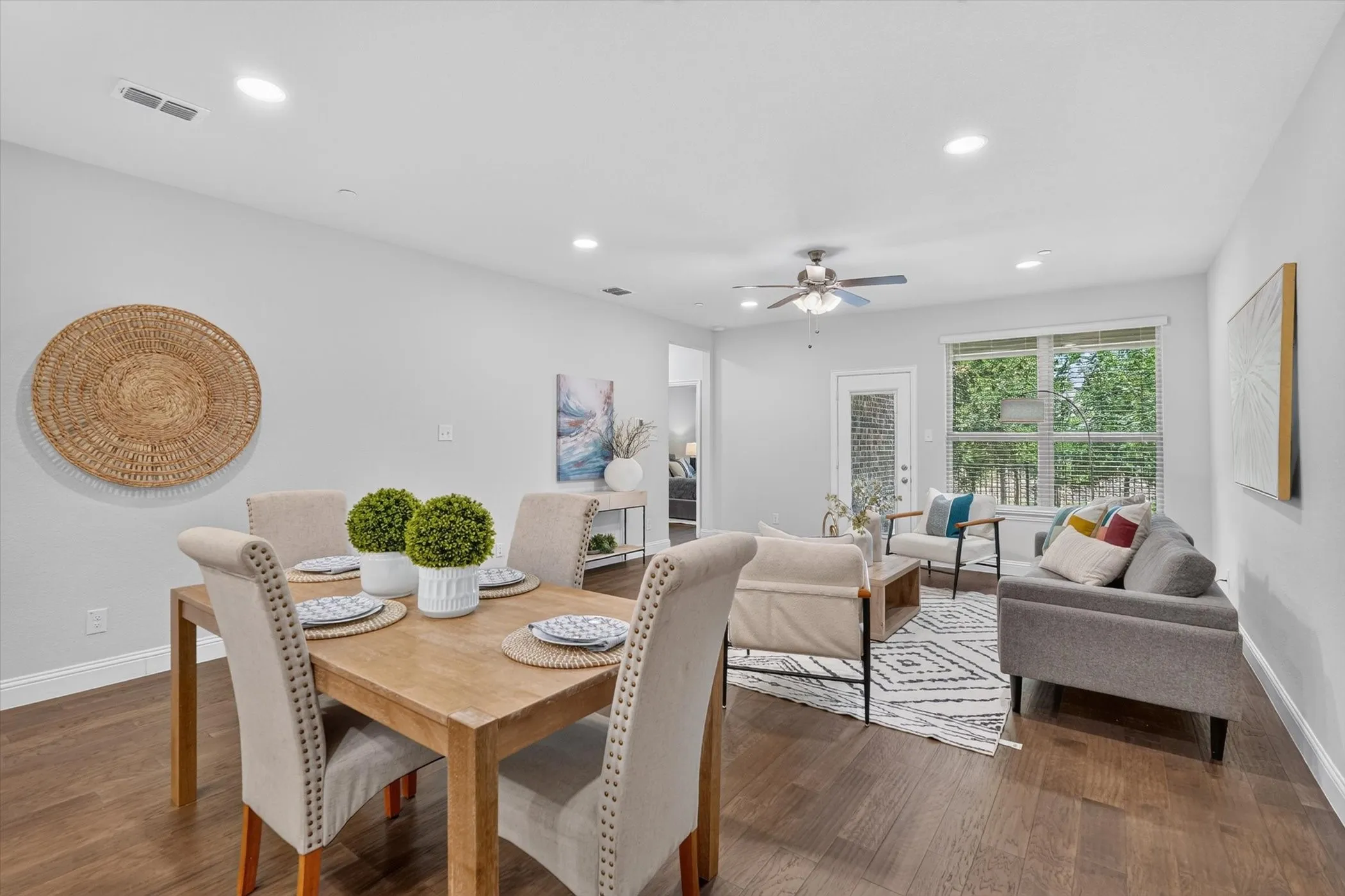 Open-concept living space featuring wood-finish flooring, recessed lighting, and a ceiling fan
