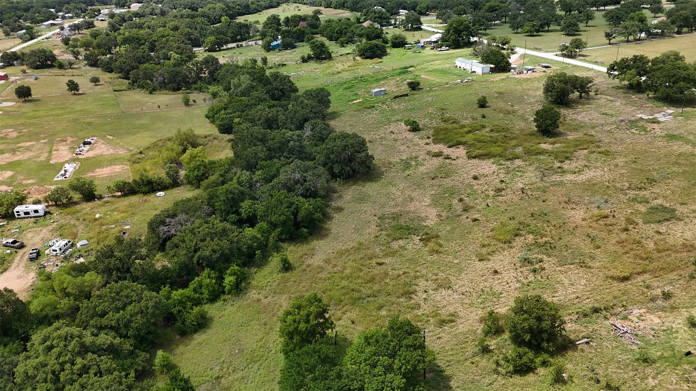 Expansive acreage featuring a mix of open fields and dense tree lines