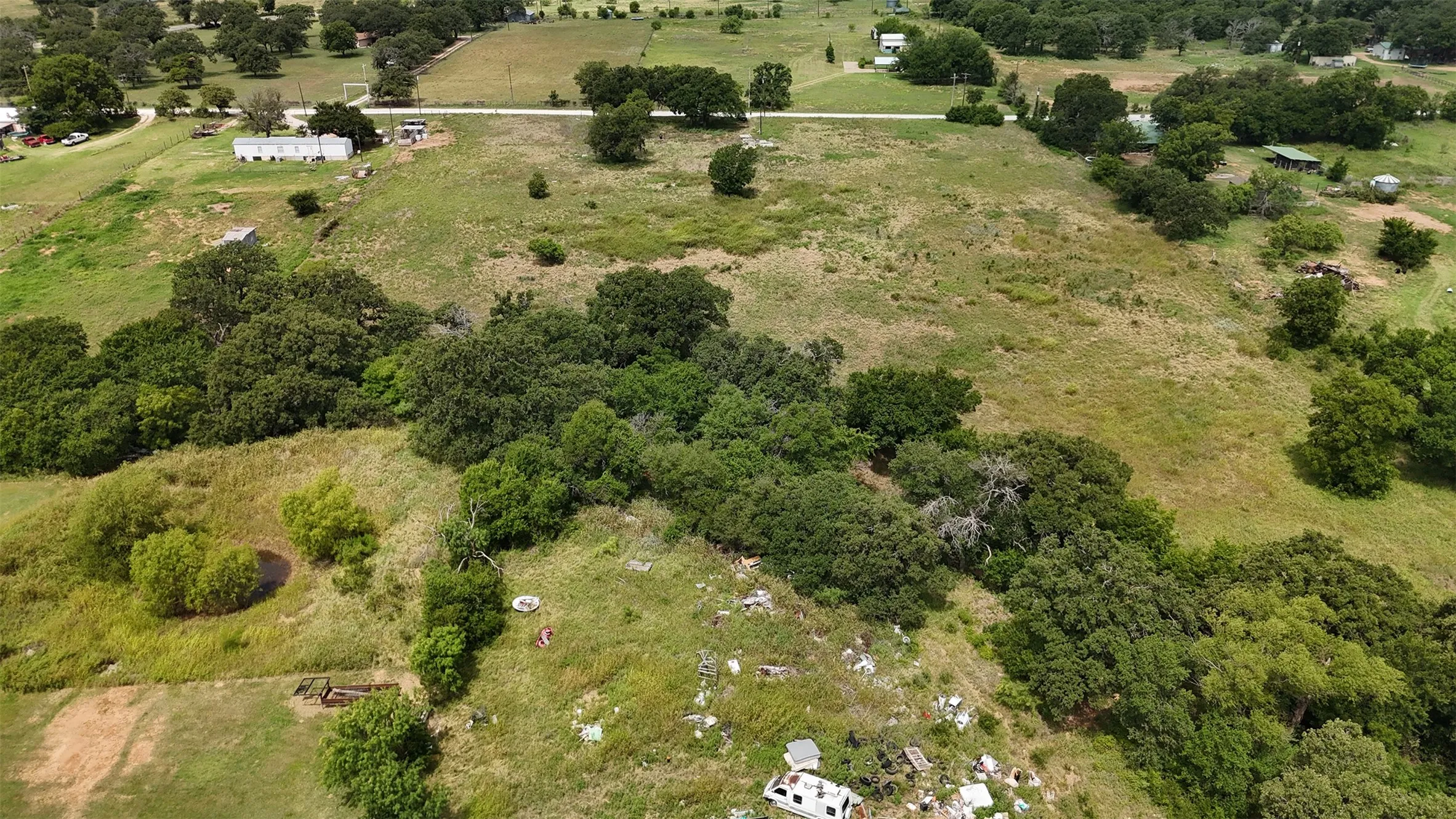 Expansive undeveloped land featuring a mixture of open fields and mature tree clusters
