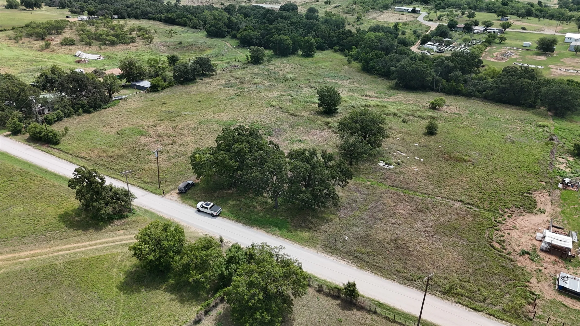 Expansive undeveloped land featuring a combination of grassy fields and scattered mature trees