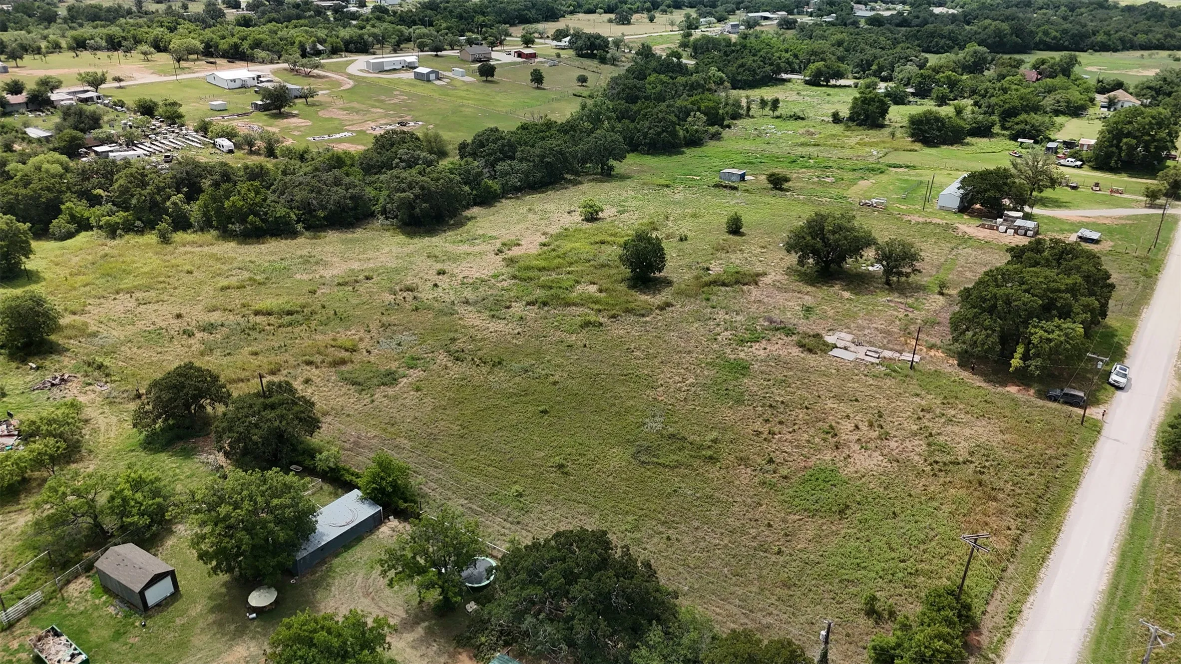Expansive undeveloped land featuring a mix of open grassy areas and mature trees