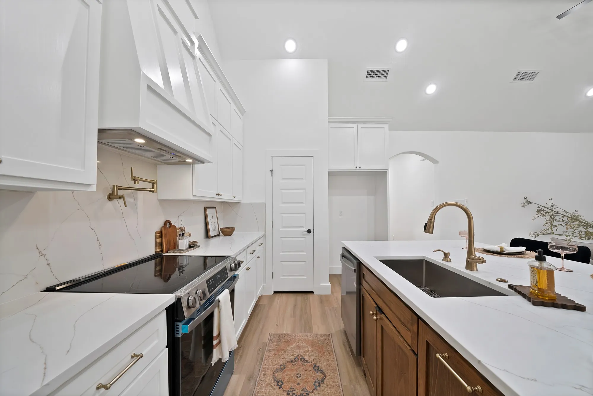 Modern kitchen with white cabinetry and a contrasting wood-finish island