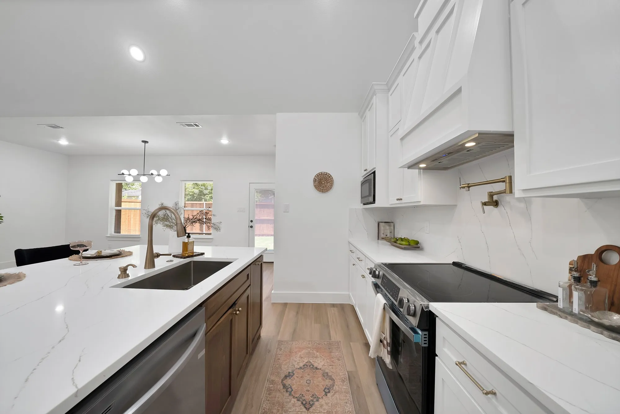 Modern kitchen featuring a large island with an undermount sink and a brushed nickel faucet