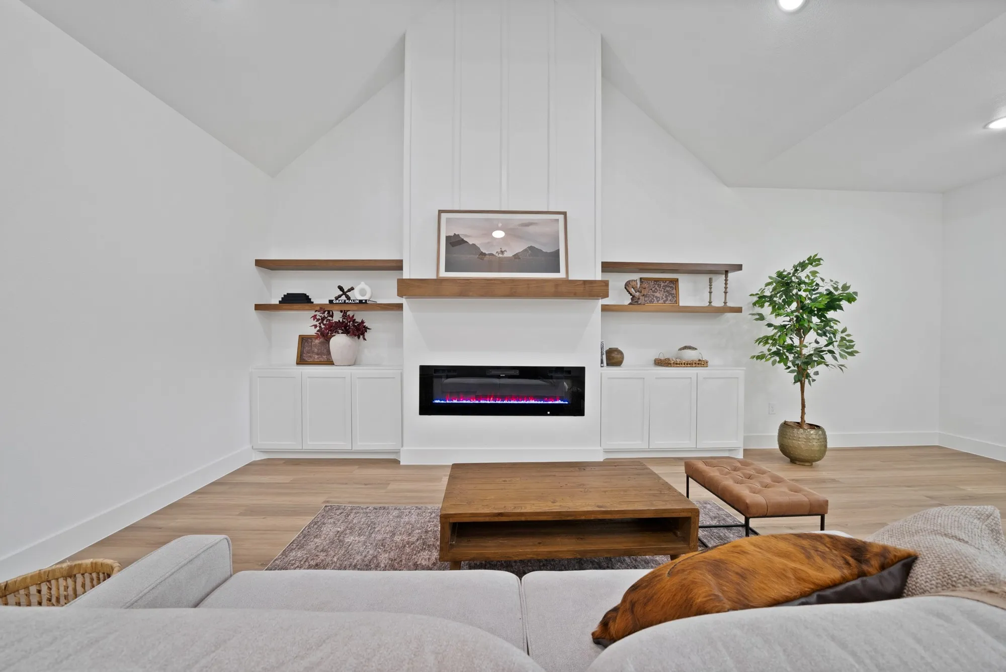 Living room featuring a vaulted ceiling, wood-finish flooring, and recessed lighting