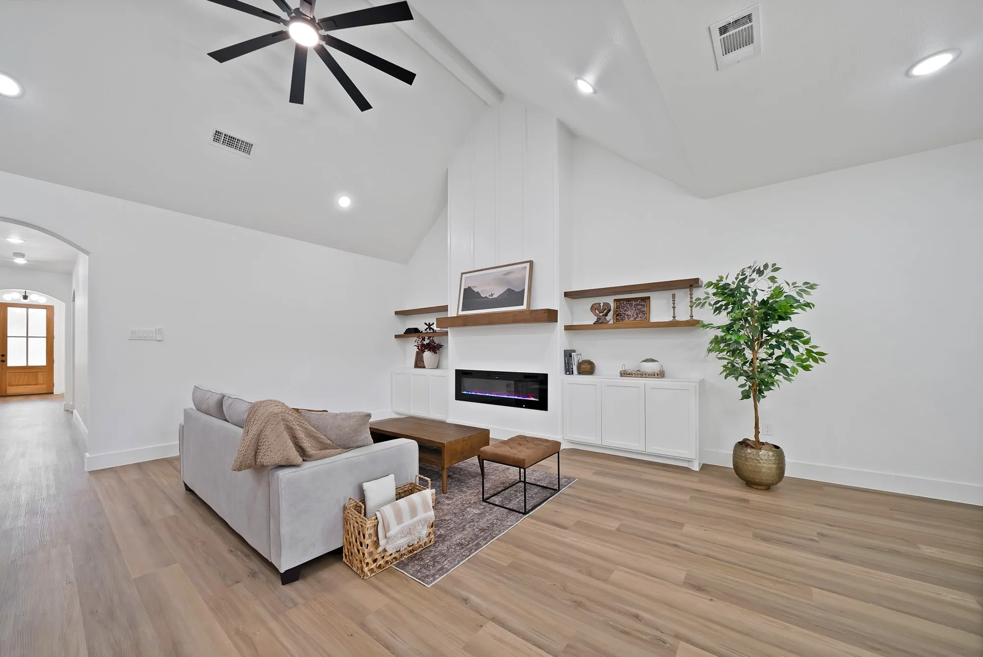 Living area featuring a vaulted ceiling with a modern ceiling fan, recessed lighting, and wood-finish flooring