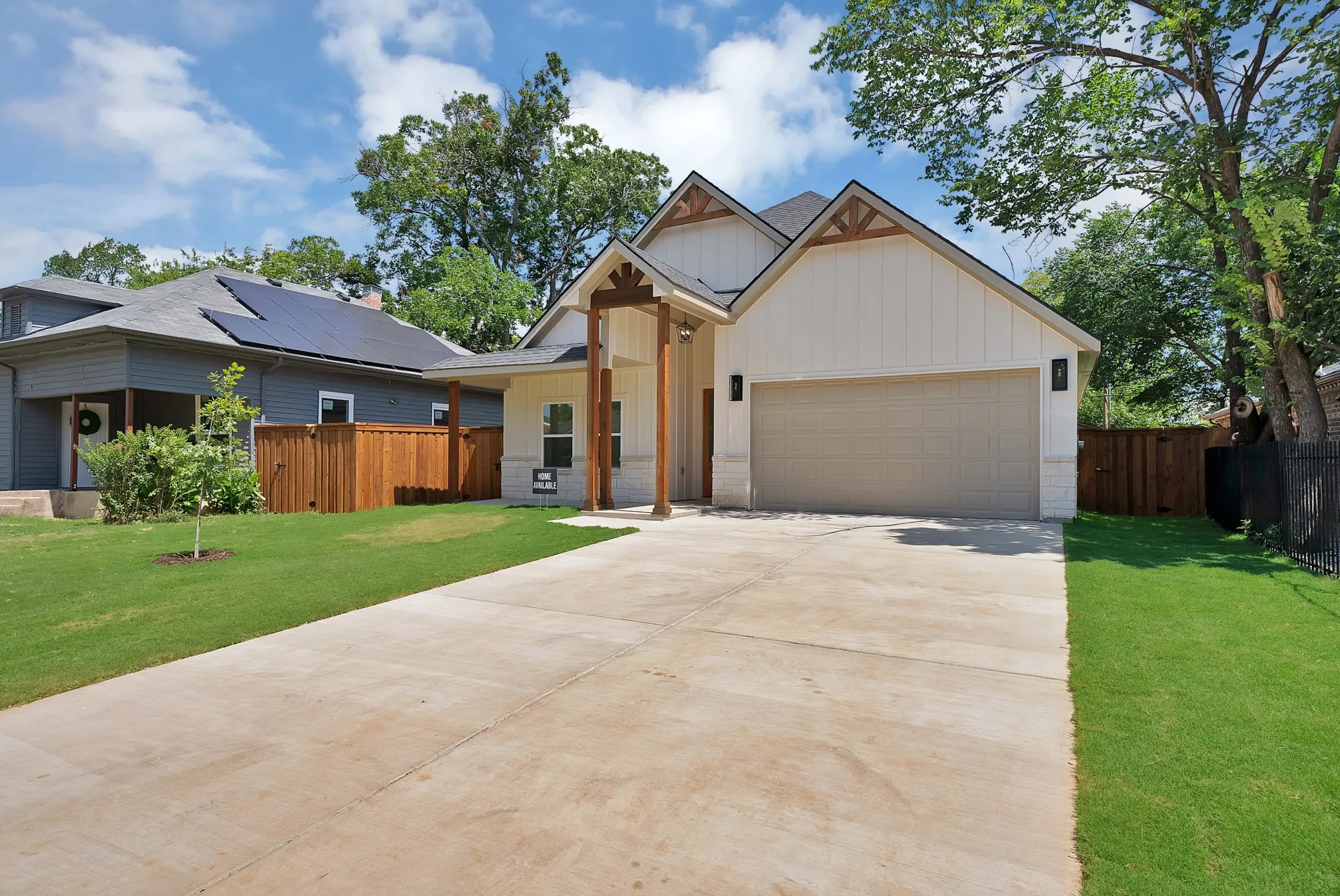 Contemporary residence featuring a two-car garage, concrete driveway, and a front yard with established landscaping