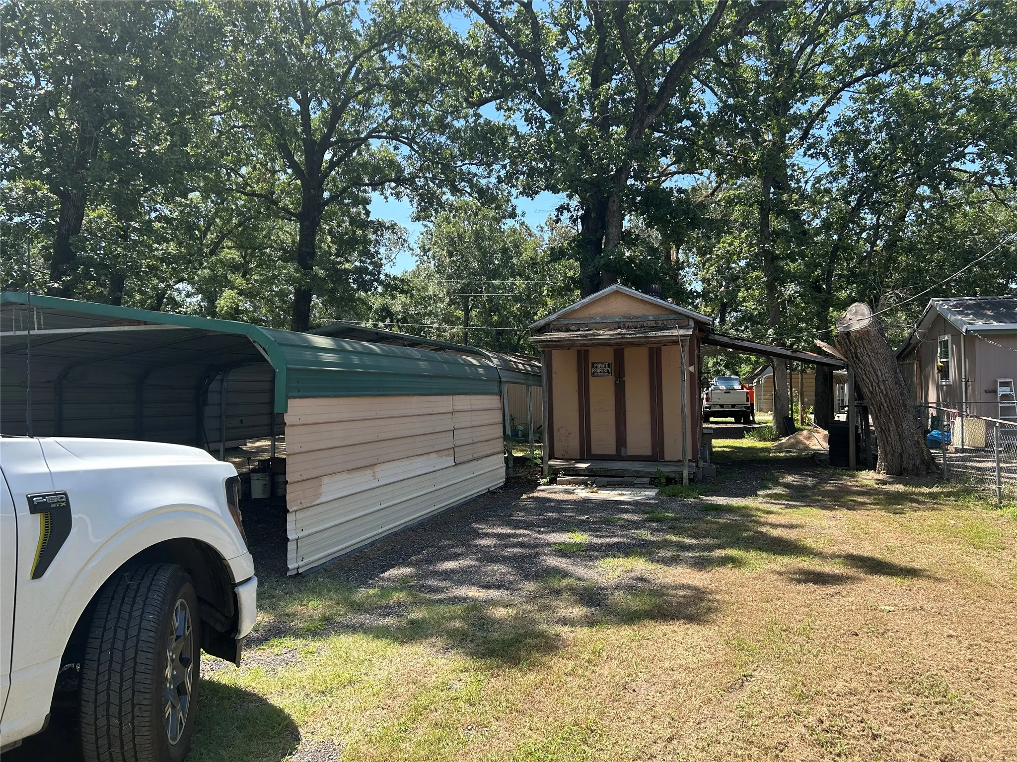 Back of property showing carports, outbuilding and additional covered parking.