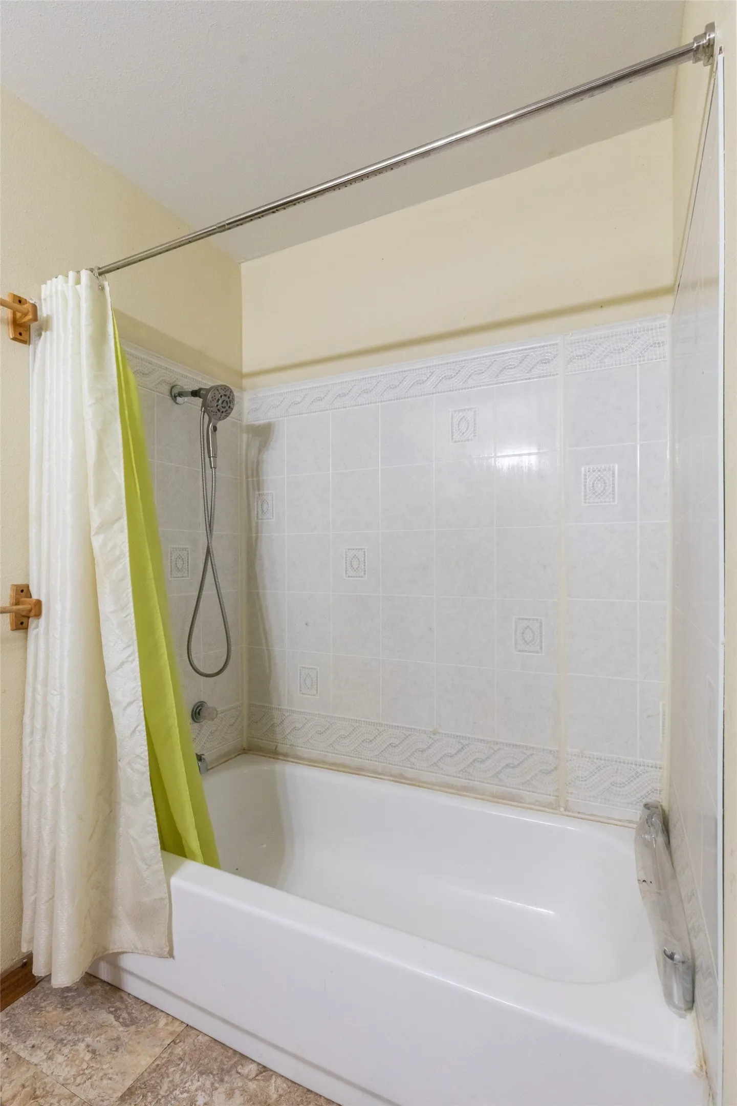 White bathtub with a tile surround featuring decorative accents