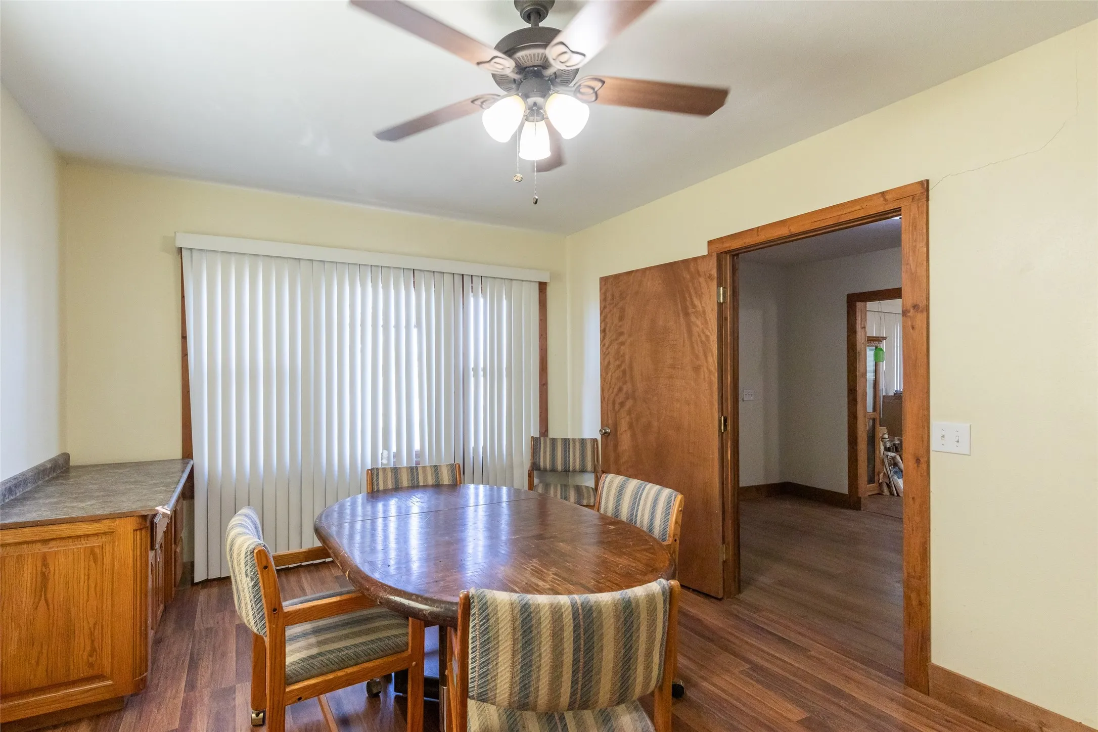 Dining area featuring wood-finish flooring, a ceiling fan with light fixture, and a built-in cabinetry unit with countertop