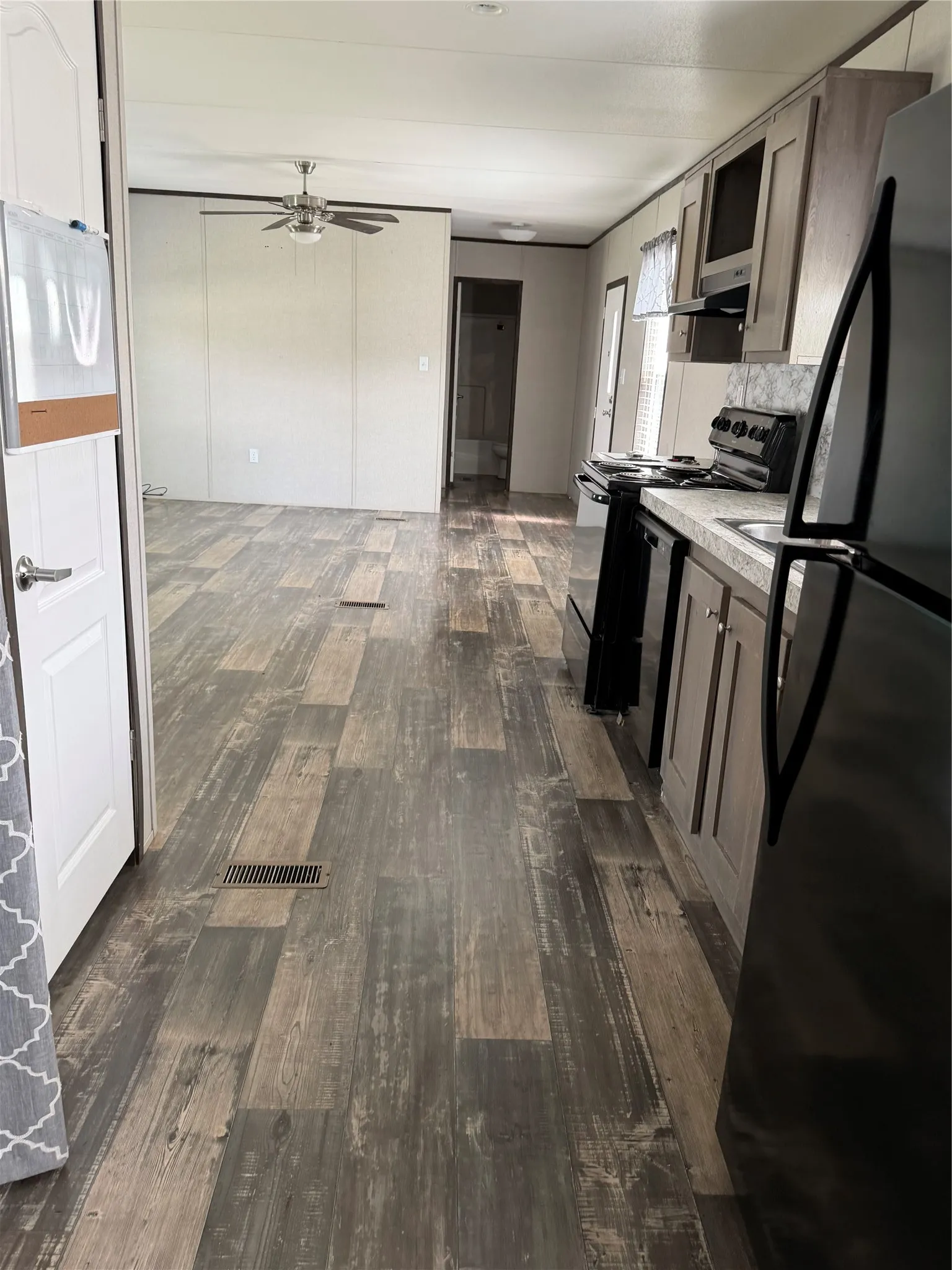 Spacious open-concept living area featuring wood-finish flooring throughout