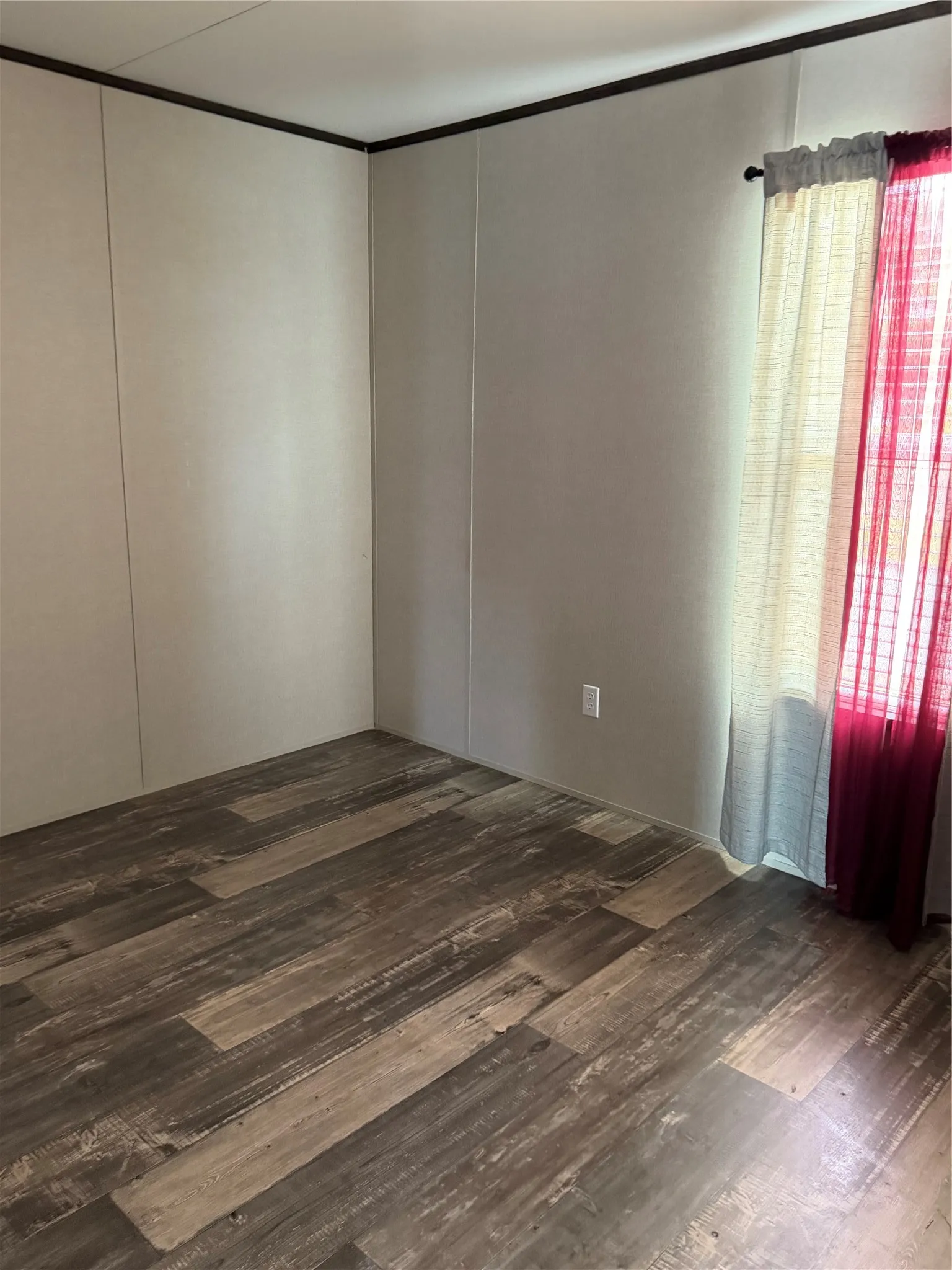 Room featuring wood-finish plank flooring and light-toned wall panels