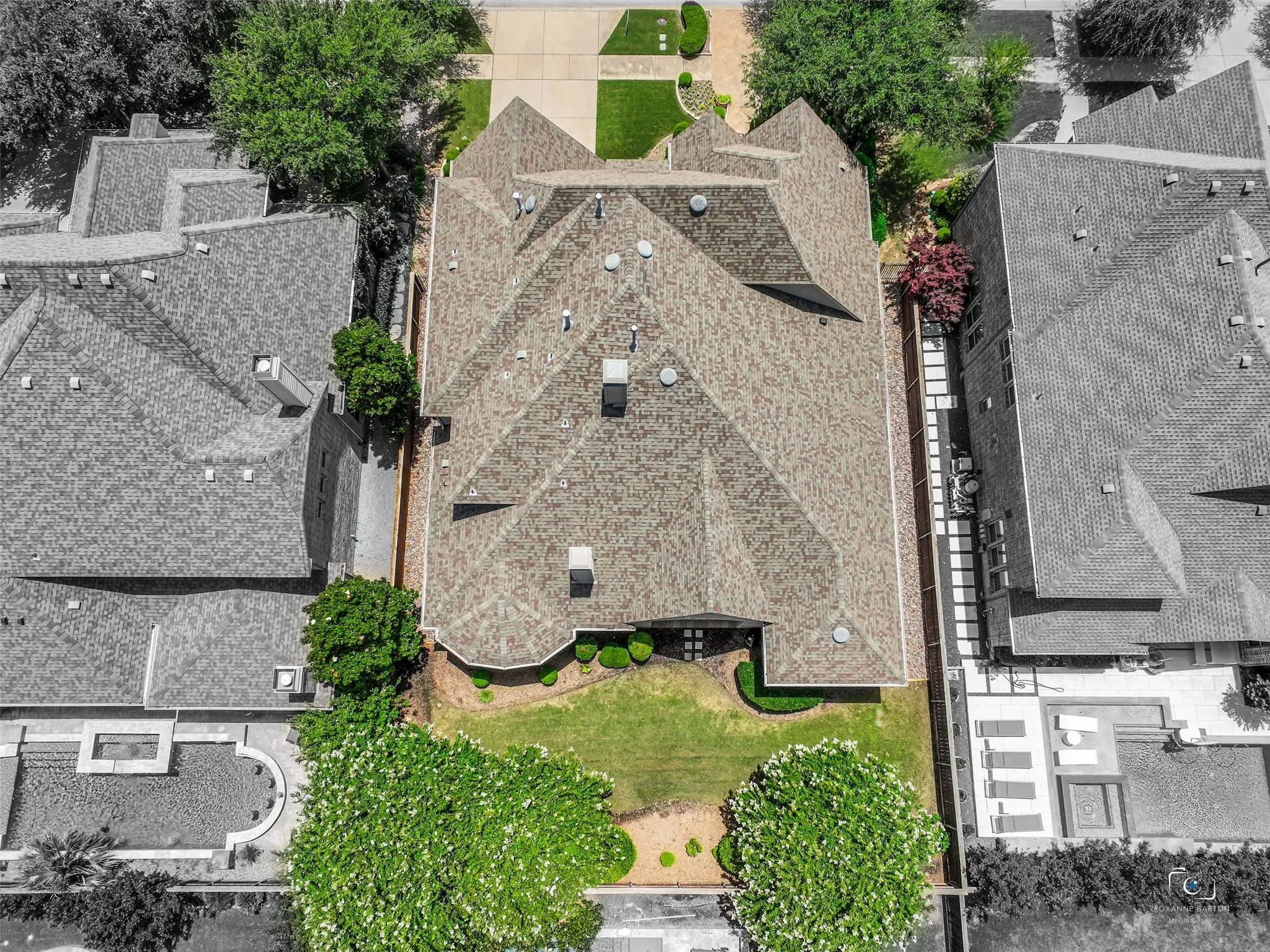 Expansive residential property featuring a multi-gabled roofline, a manicured lawn, and mature landscaping