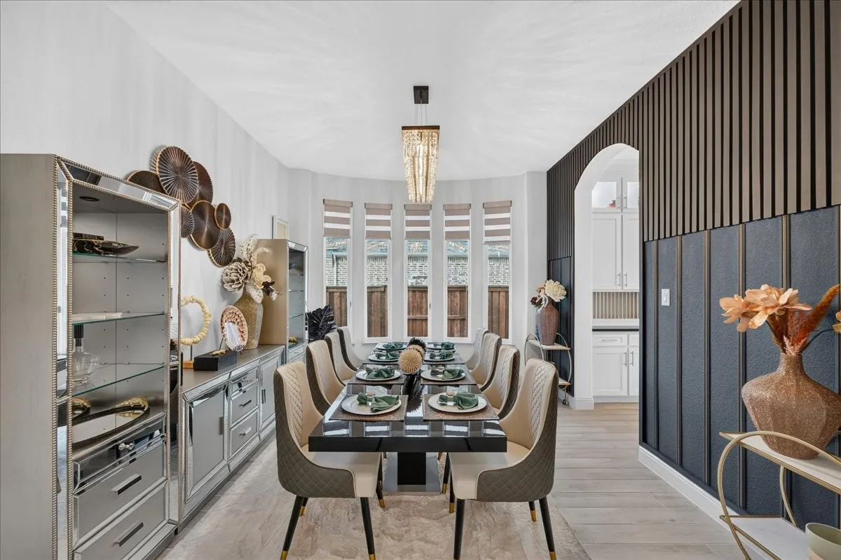 Dining area featuring a contemporary chandelier, a bay window with blinds, and wood-finish flooring