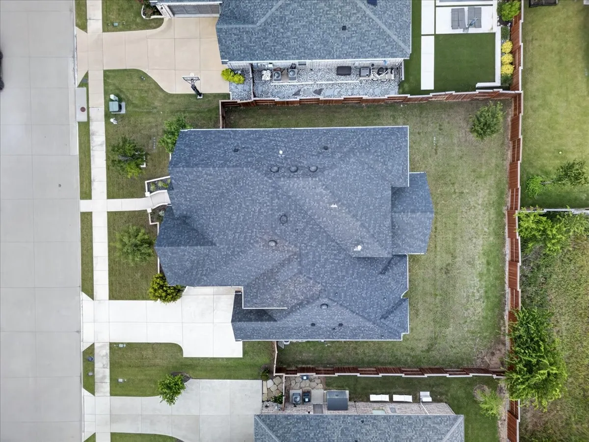 Property with a shingle roof, concrete driveway, and a fenced backyard