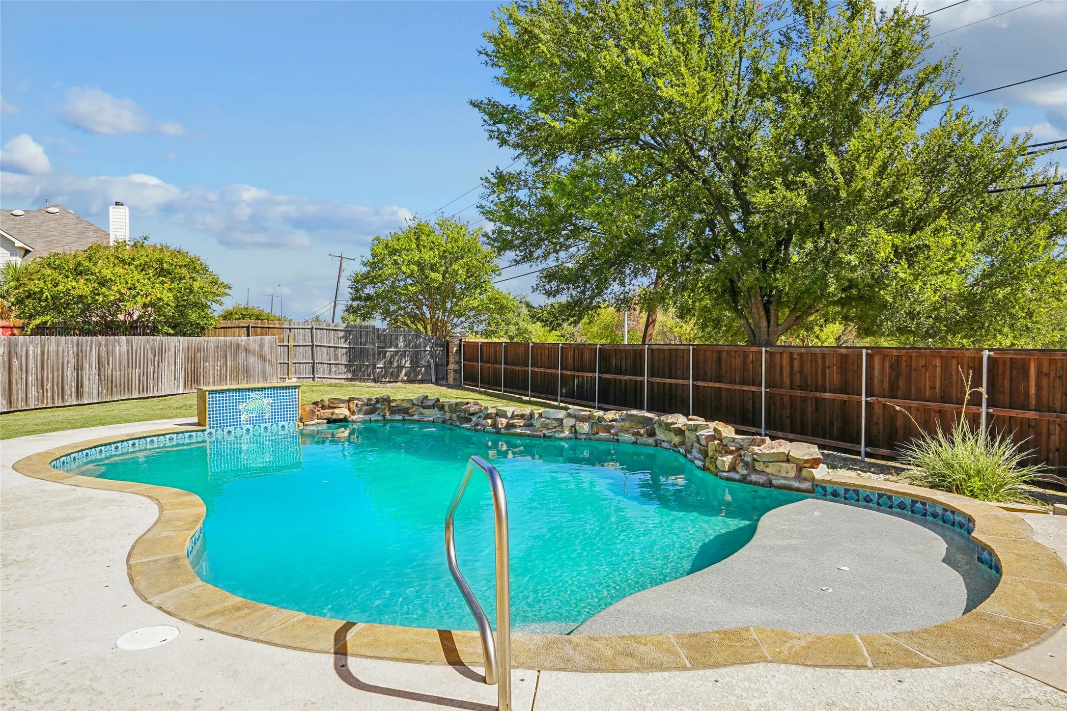 Freeform swimming pool with a stone coping and integrated rock features