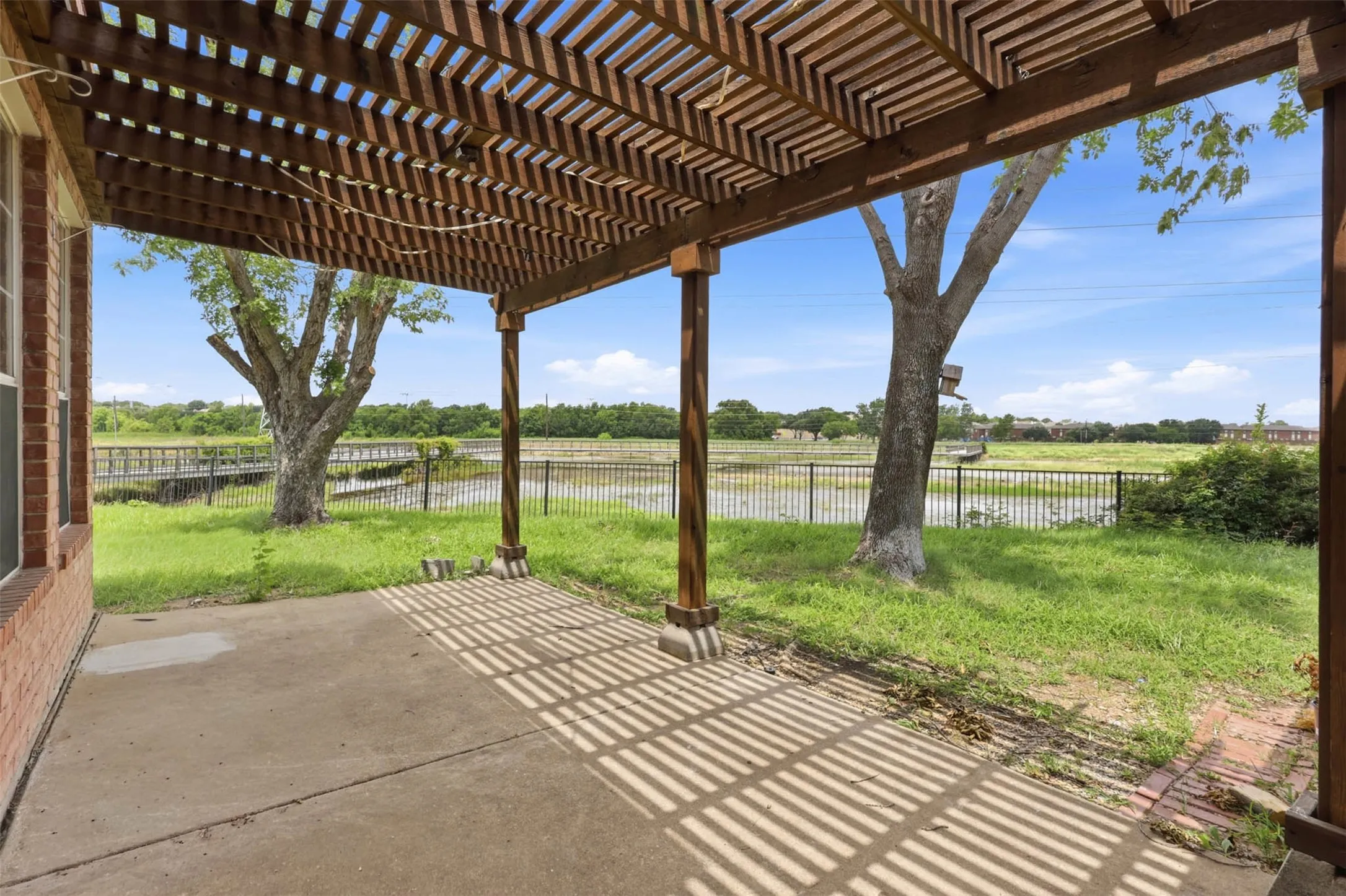 Concrete patio with a wooden pergola structure