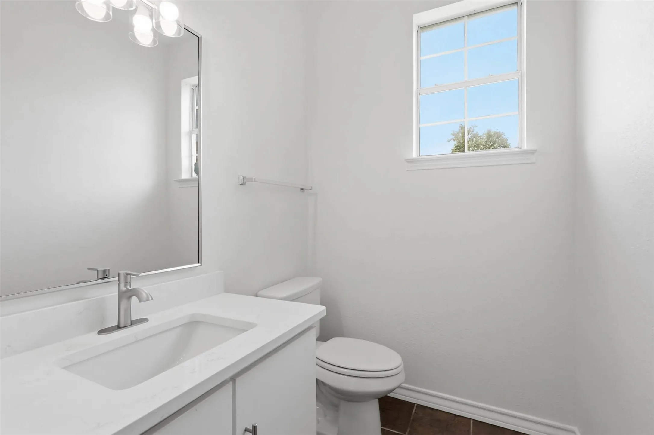 Bathroom vanity featuring a rectangular undermount sink, a chrome faucet, and a light-toned countertop