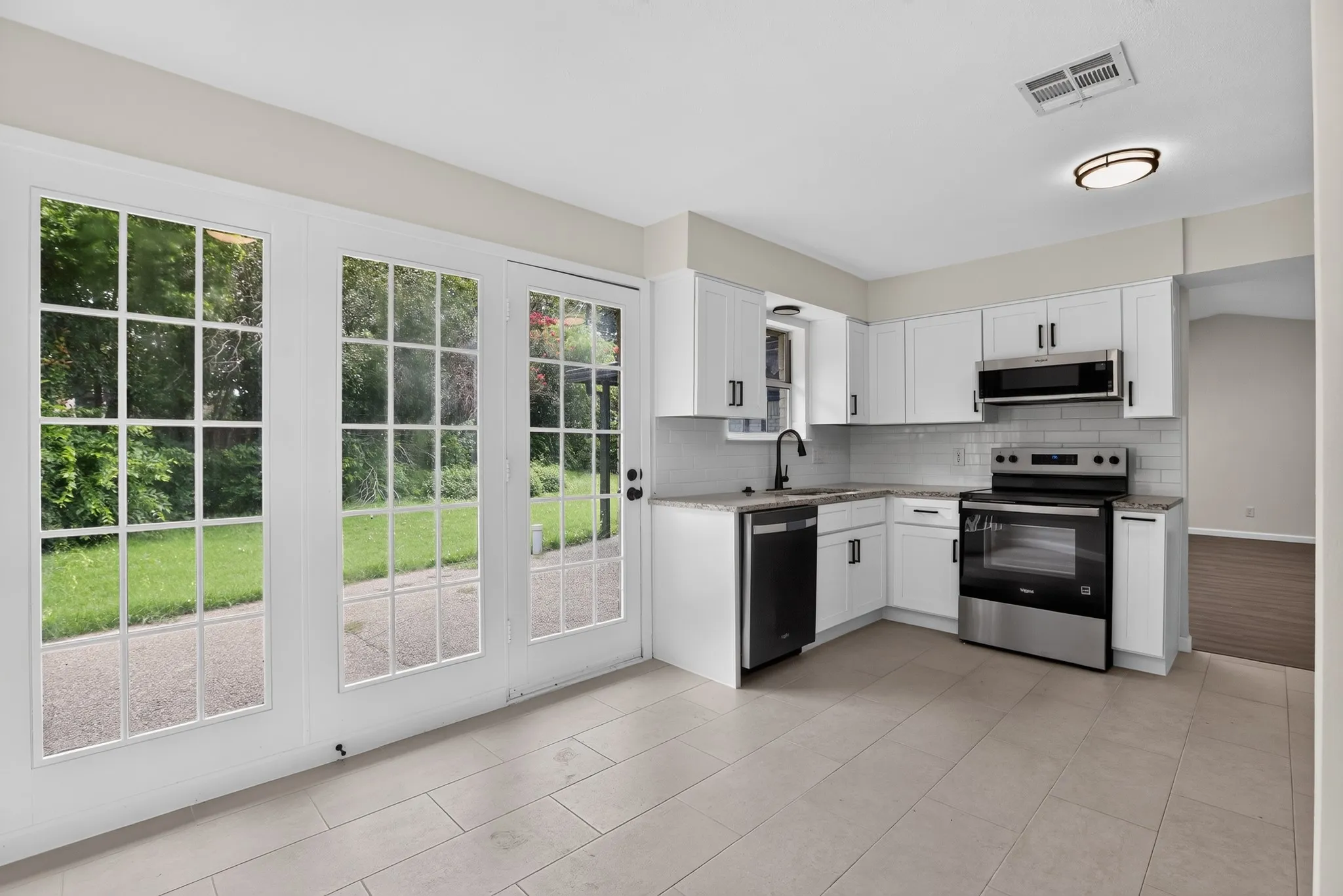 Kitchen features white shaker cabinetry, stainless steel appliances, light-toned countertops, and a white subway tile​​‌​​​​‌​​‌‌​‌‌​​​‌‌​‌​‌​‌​​​‌​​ backsplash